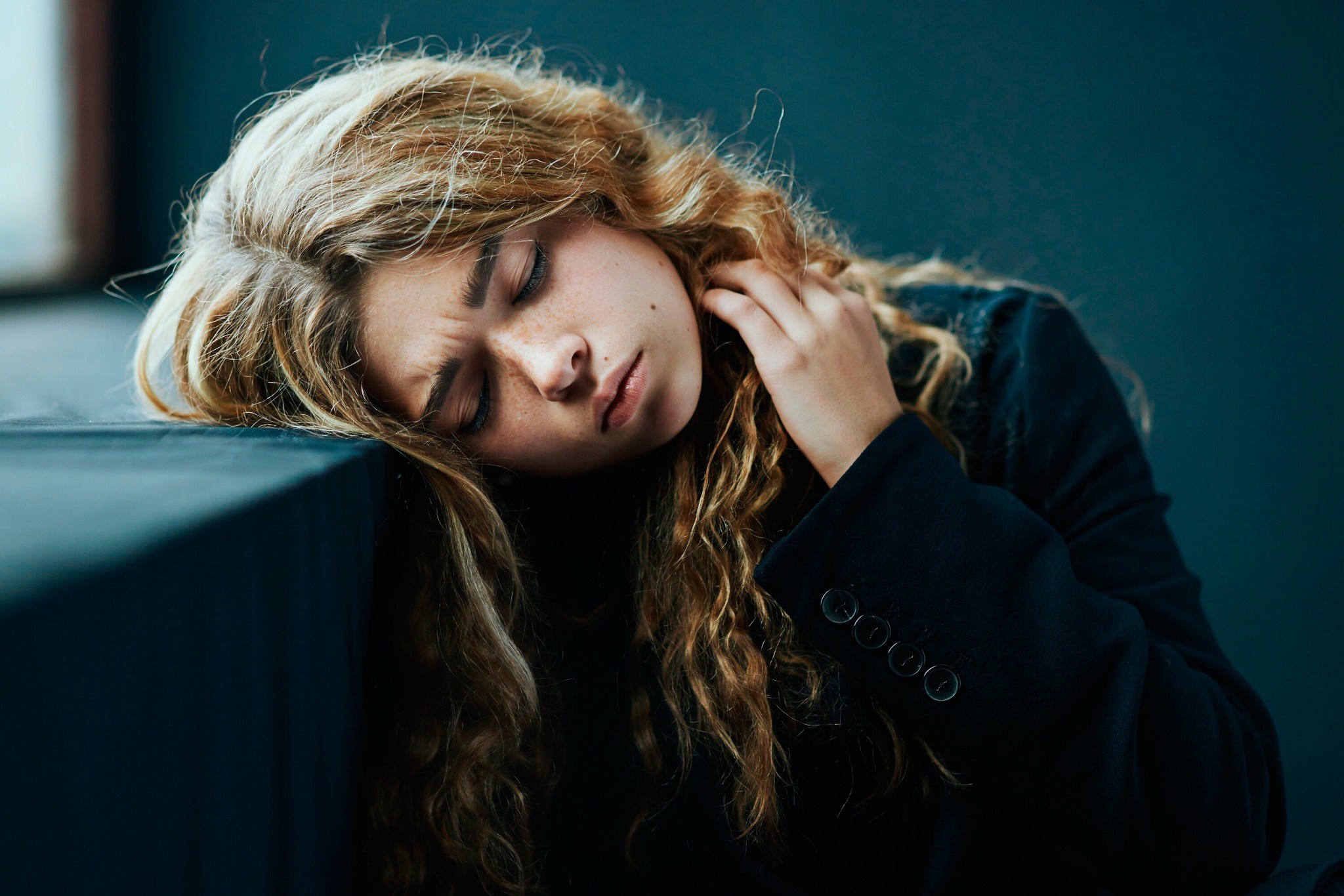 Woman with curly brown hair resting her head HD Wallpaper