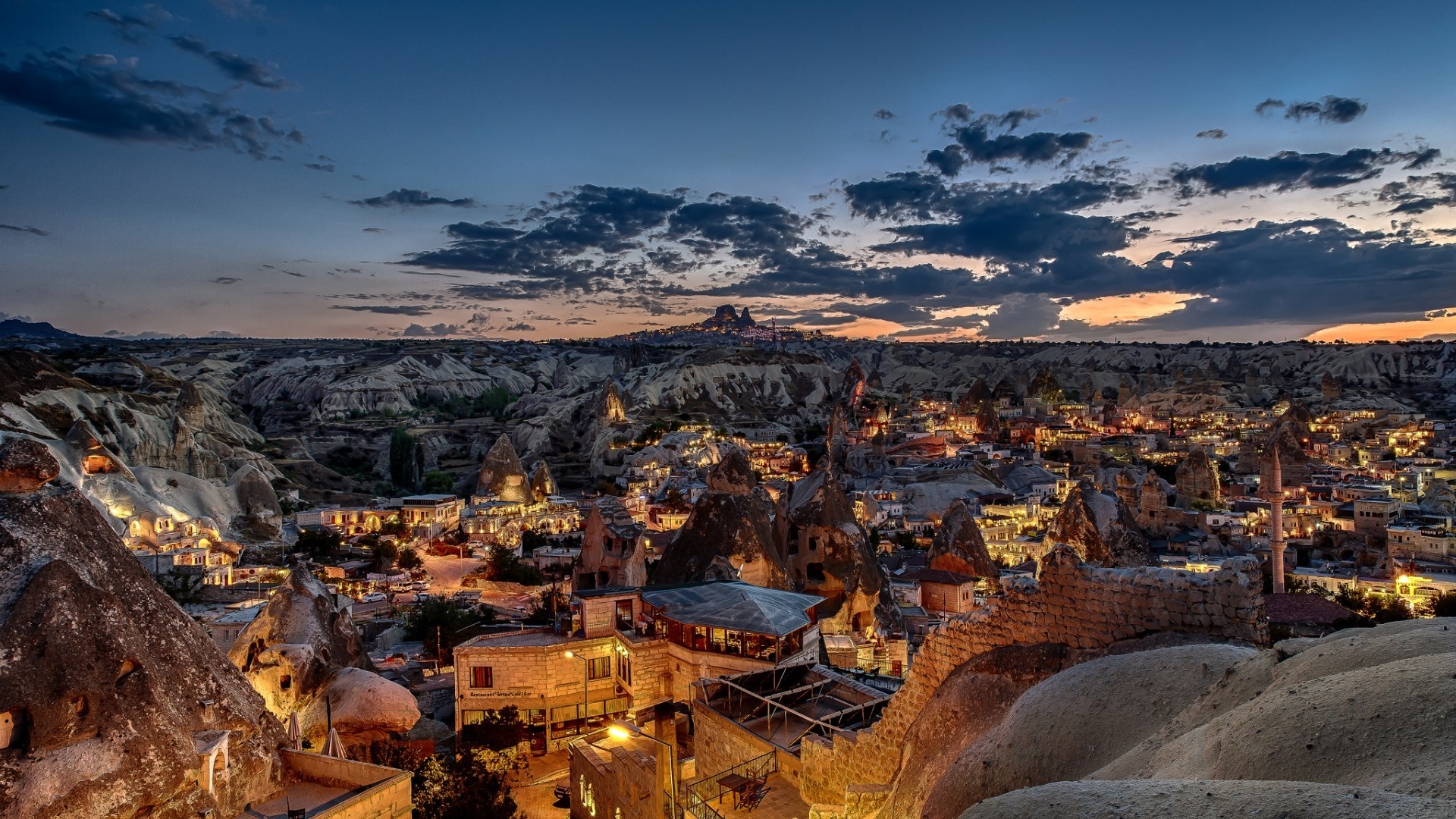Cappadocia landscape at dusk with illuminated cave dwellings HD Wallpaper