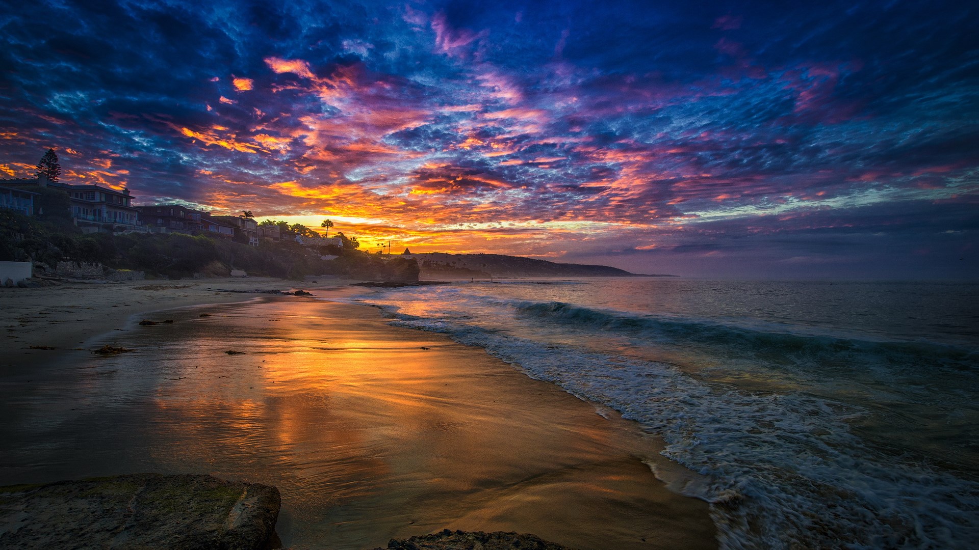 Sunset over a beach with colorful clouds and ocean waves HD Wallpaper