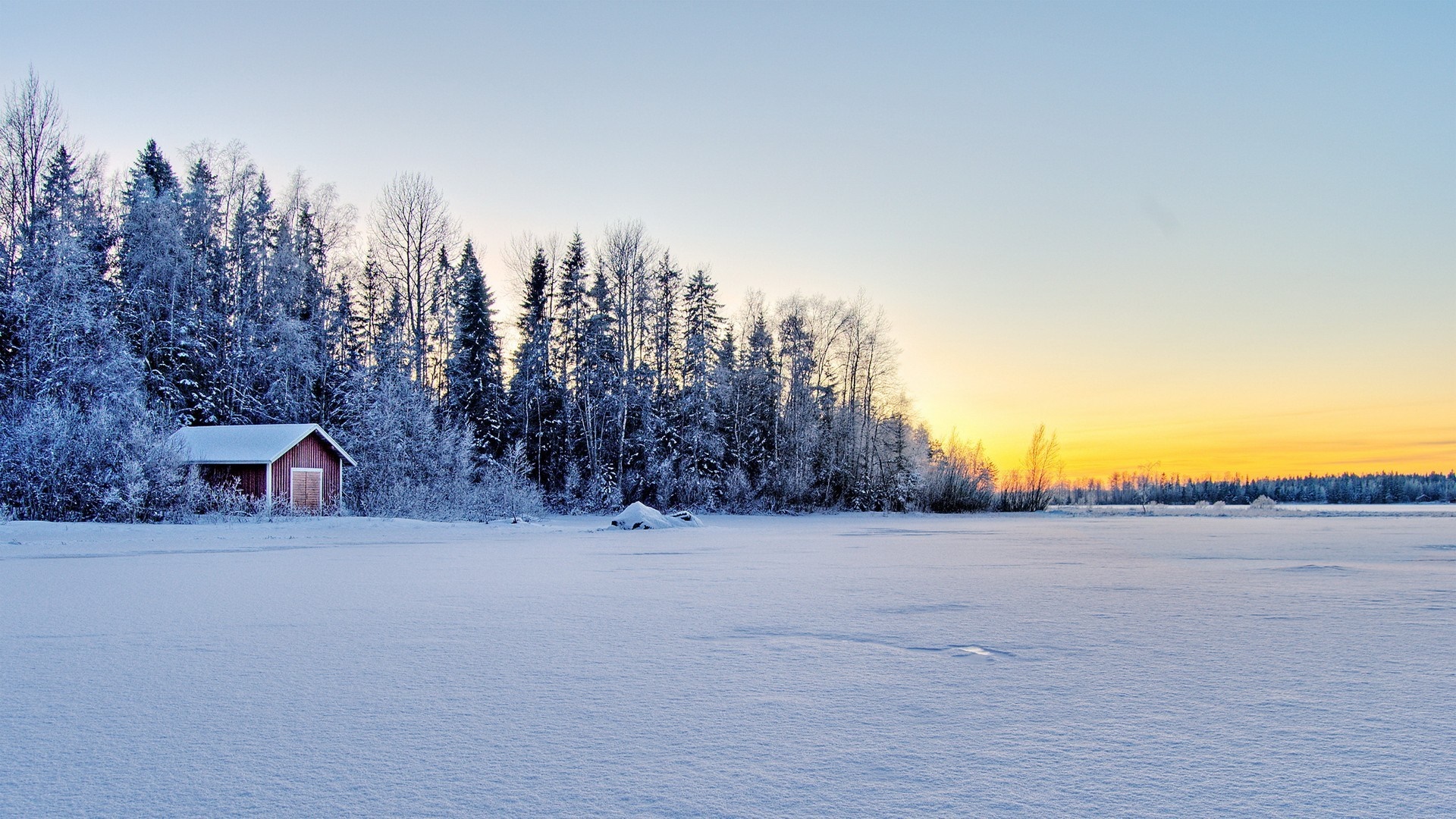 Snowy landscape with a red cabin and forest at sunset HD Wallpaper