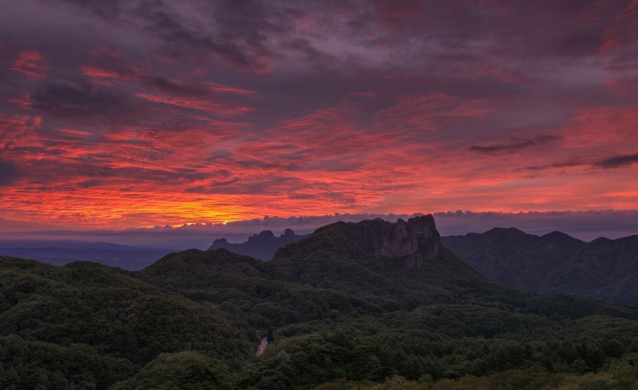 Dramatic sunset over forested mountains HD Wallpaper