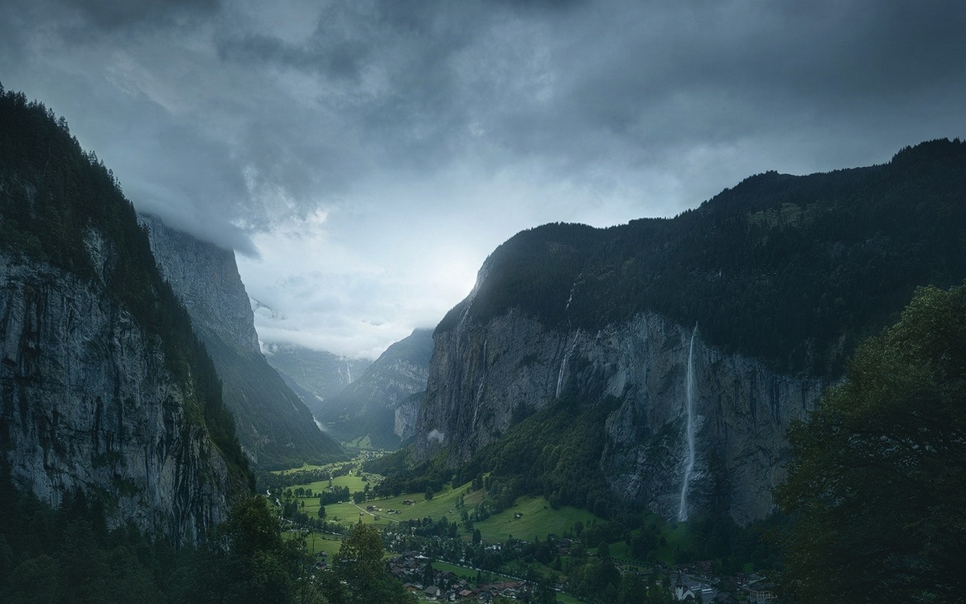 Valley with mountains, waterfall, and village in Switzerland HD Wallpaper
