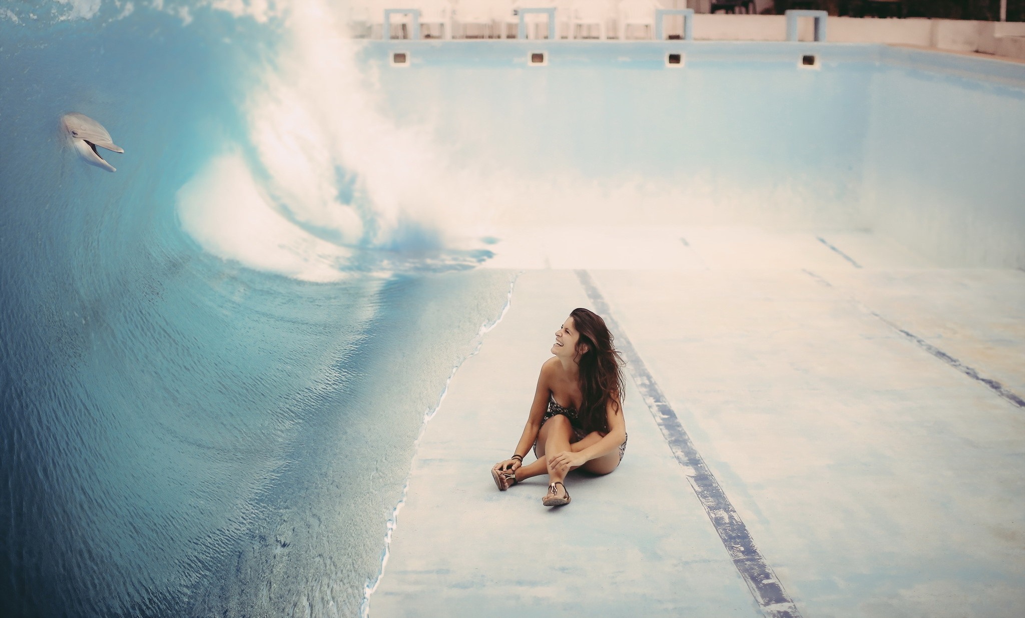 Woman sitting by a wave in an empty pool with a dolphin HD Wallpaper