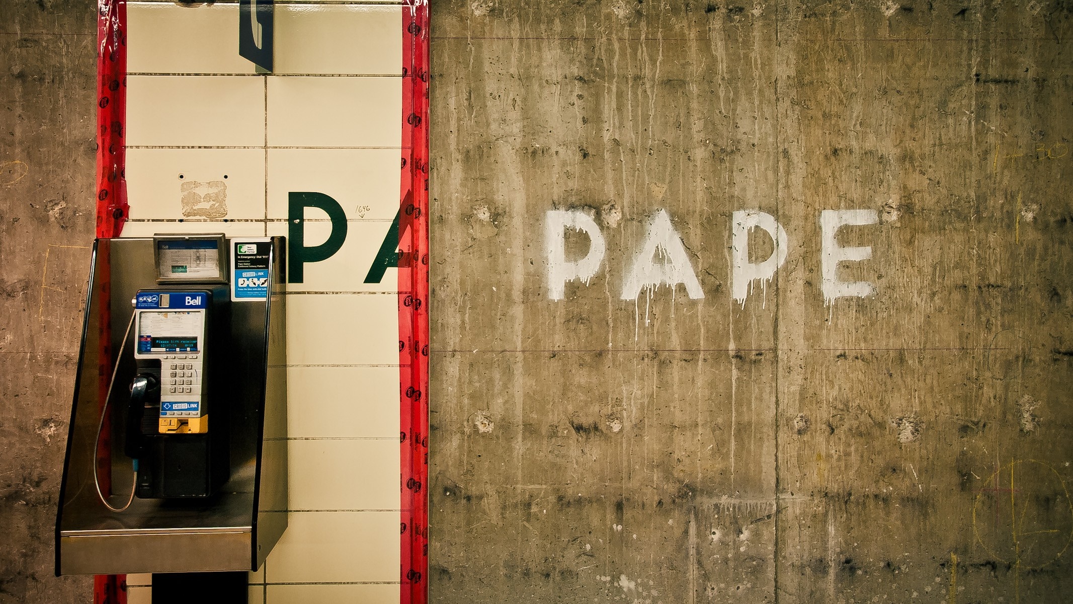 Payphone on a tiled wall with "PAPE" graffiti HD Wallpaper