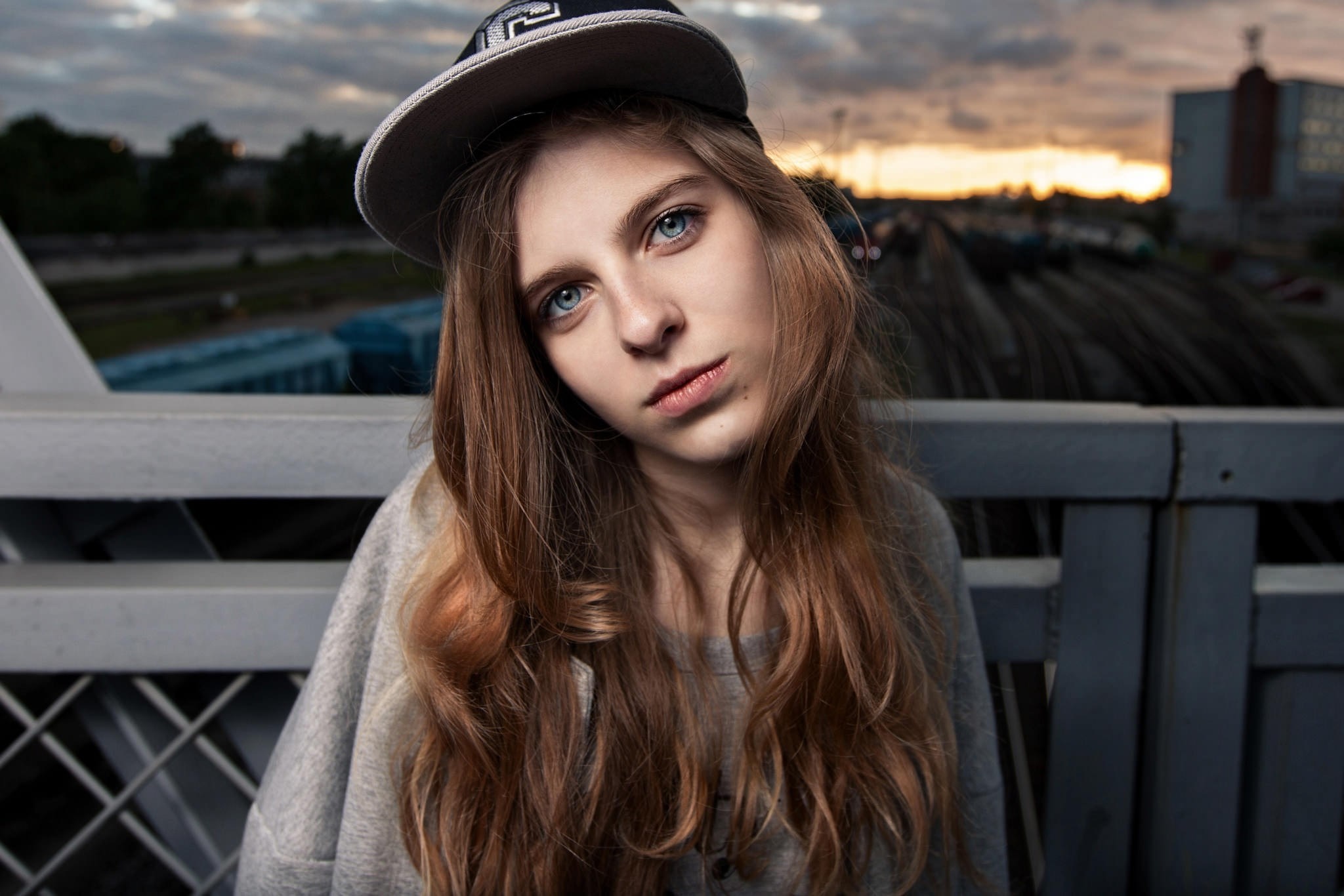 Young woman with blue eyes wearing a baseball cap HD Wallpaper