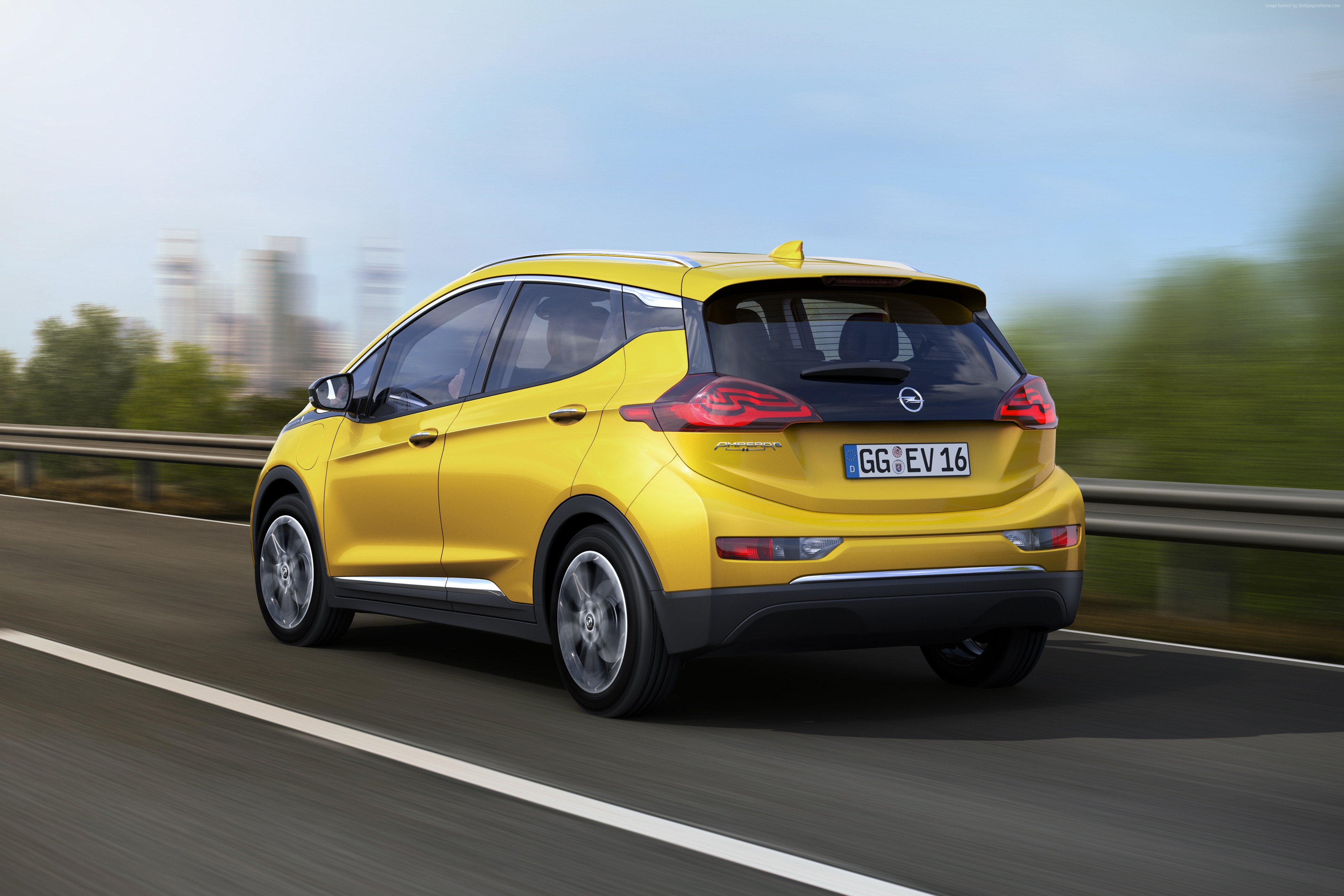 Yellow Opel Ampera-e driving on a road HD Wallpaper