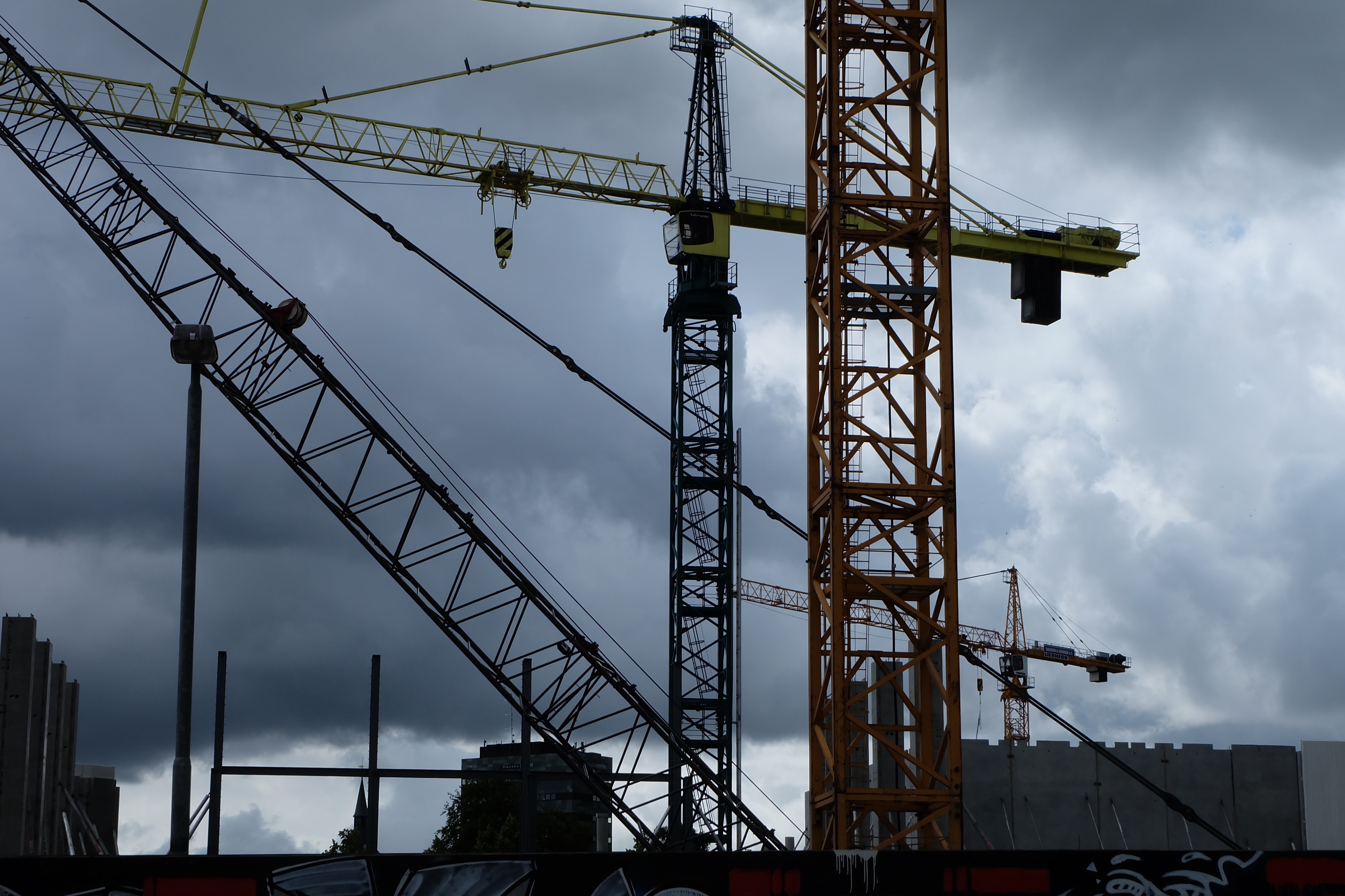Construction cranes against a cloudy sky HD Wallpaper
