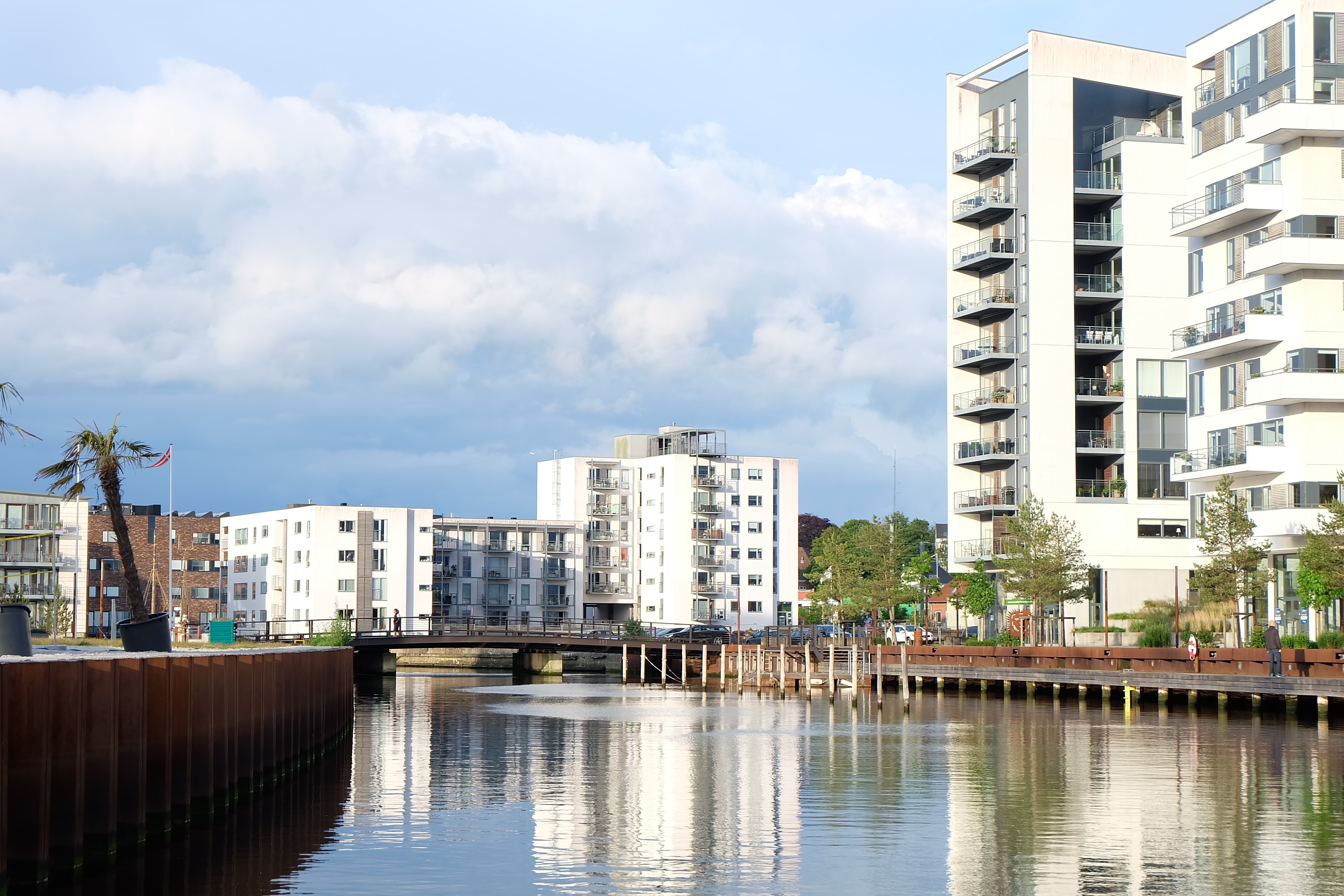 Modern apartment buildings along a canal with a bridge HD Wallpaper