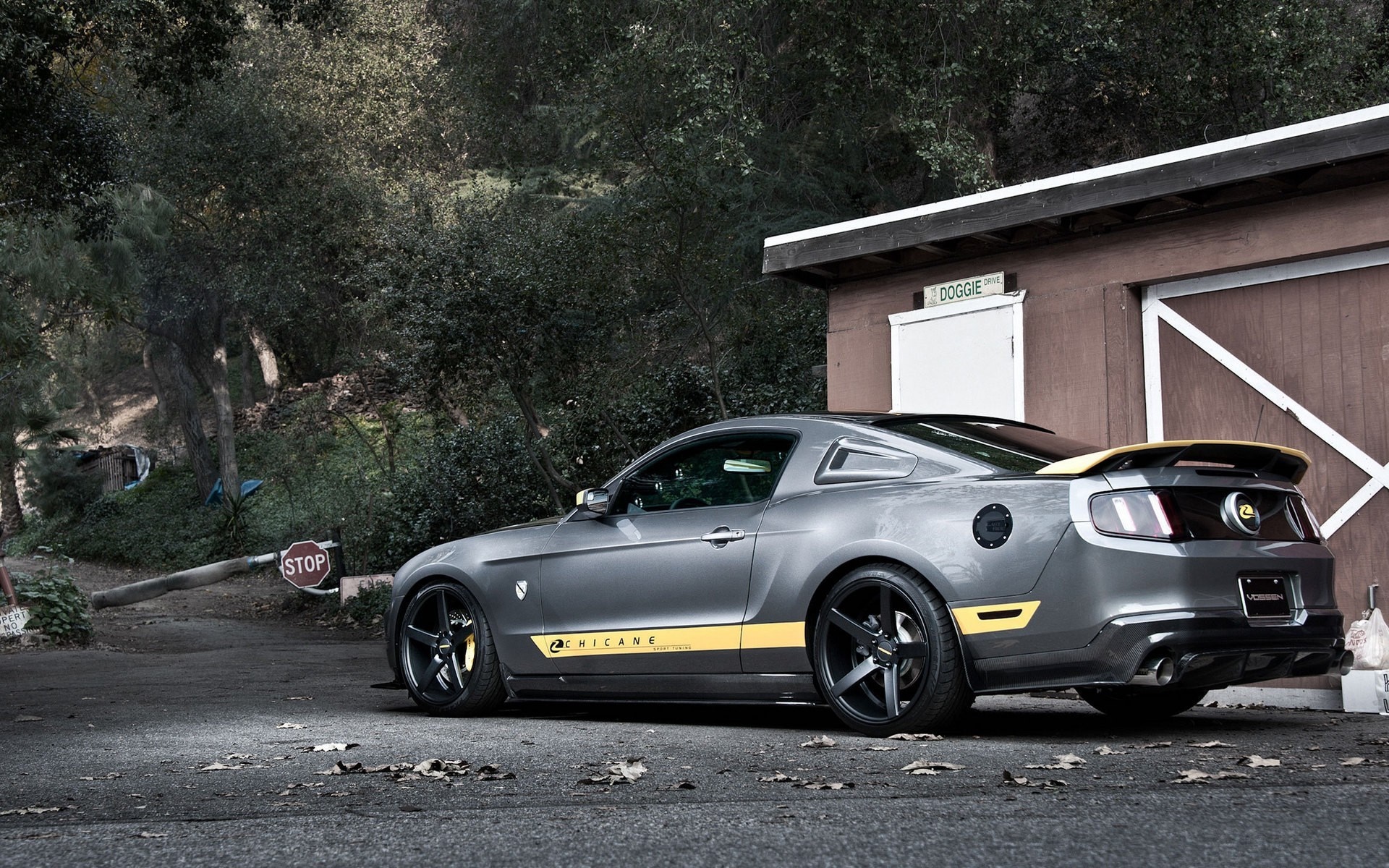 Gray Ford Mustang with yellow accents parked near a building HD Wallpaper