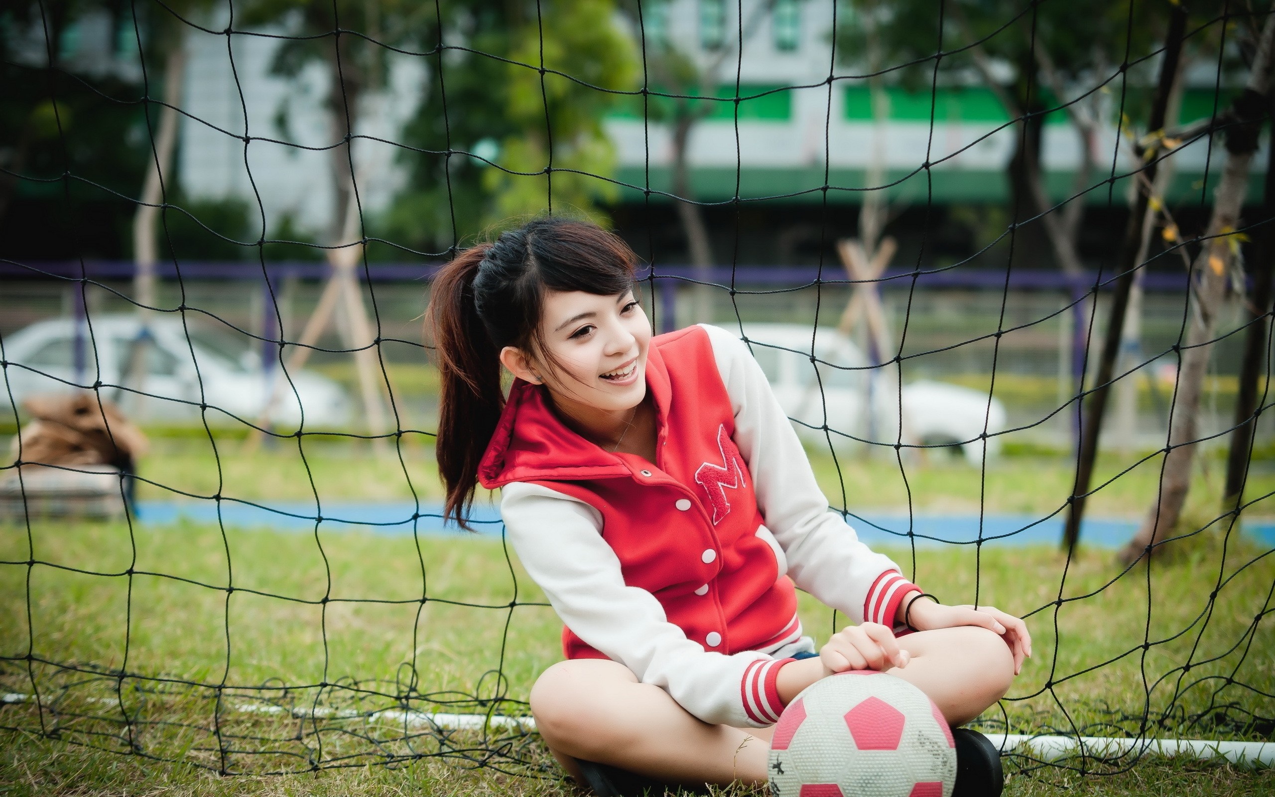 Young woman in a red jacket with a soccer ball HD Wallpaper