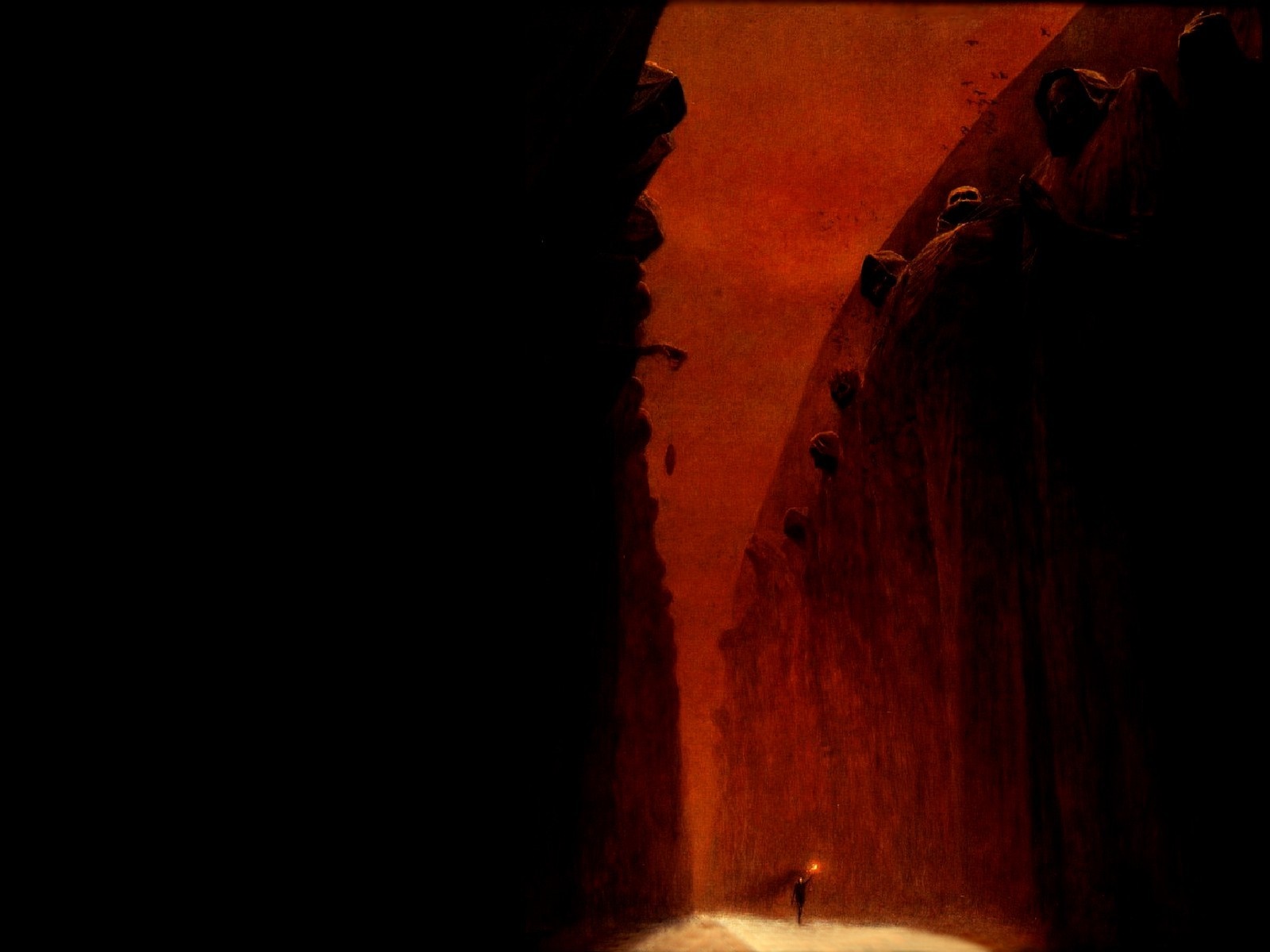 A lone figure with a lantern in a dark, rocky canyon HD Wallpaper