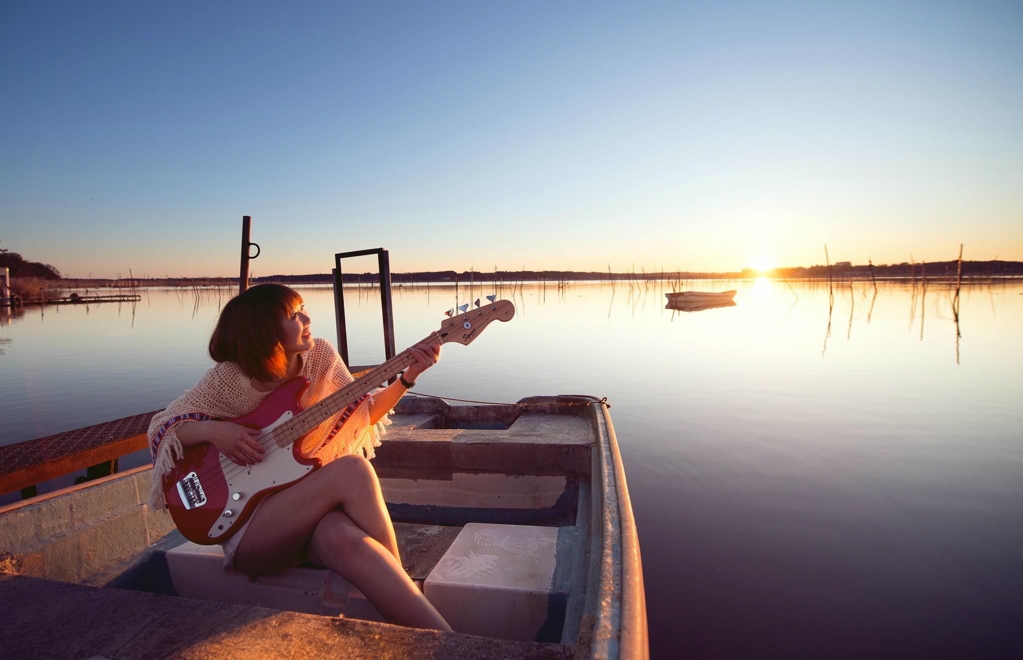 Woman playing bass guitar in a boat at sunset HD Wallpaper
