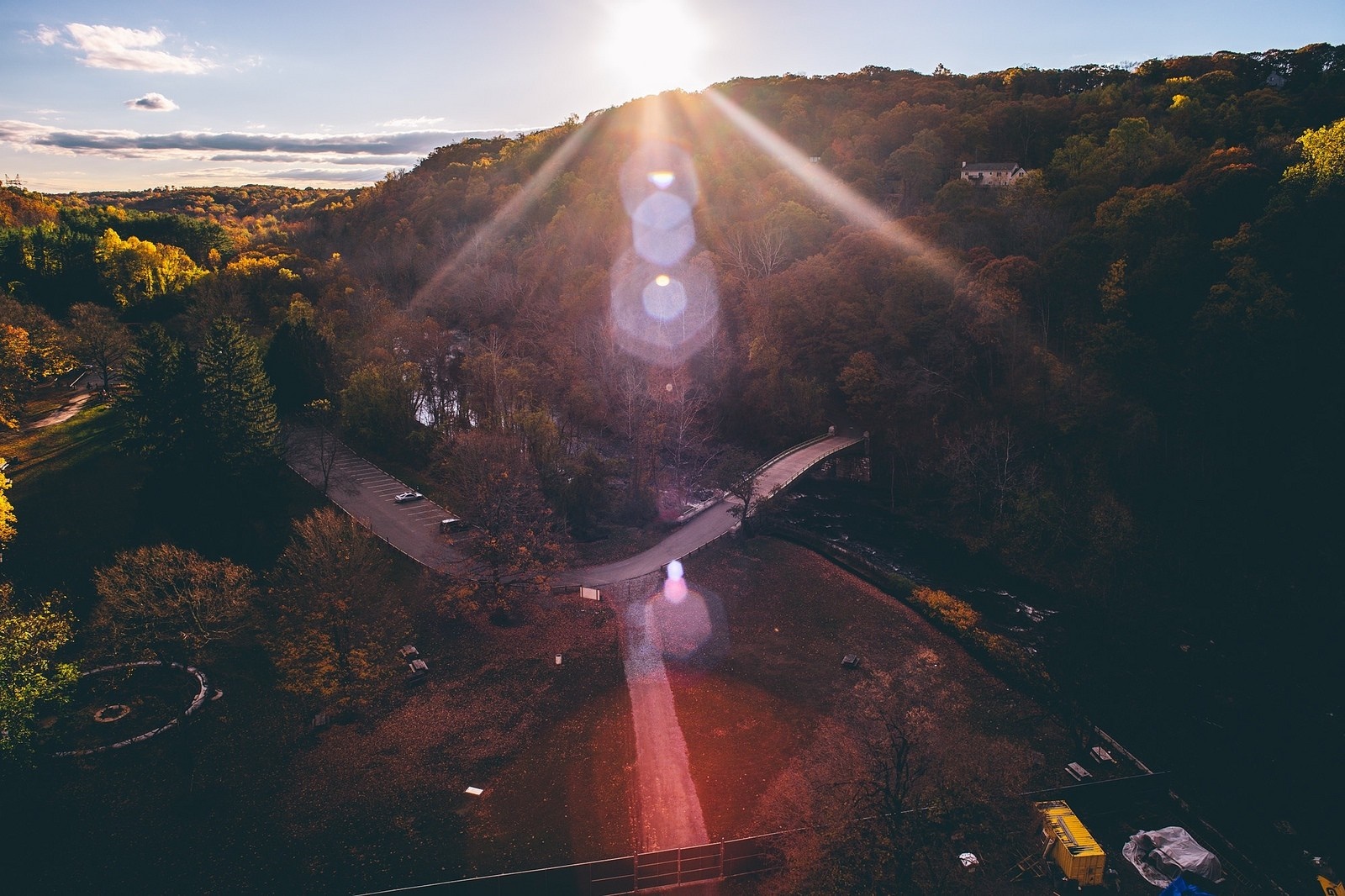 Aerial view of a park with a bridge and sun flares HD Wallpaper