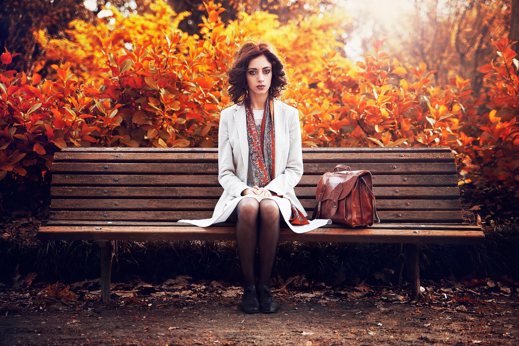 Woman sitting on a park bench in autumn HD Wallpaper