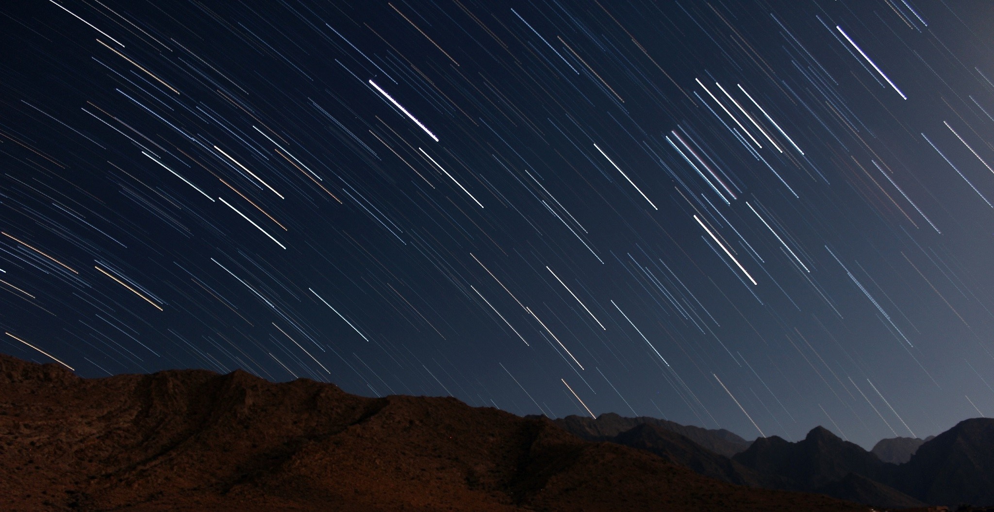 Star trails over mountains at night HD Wallpaper