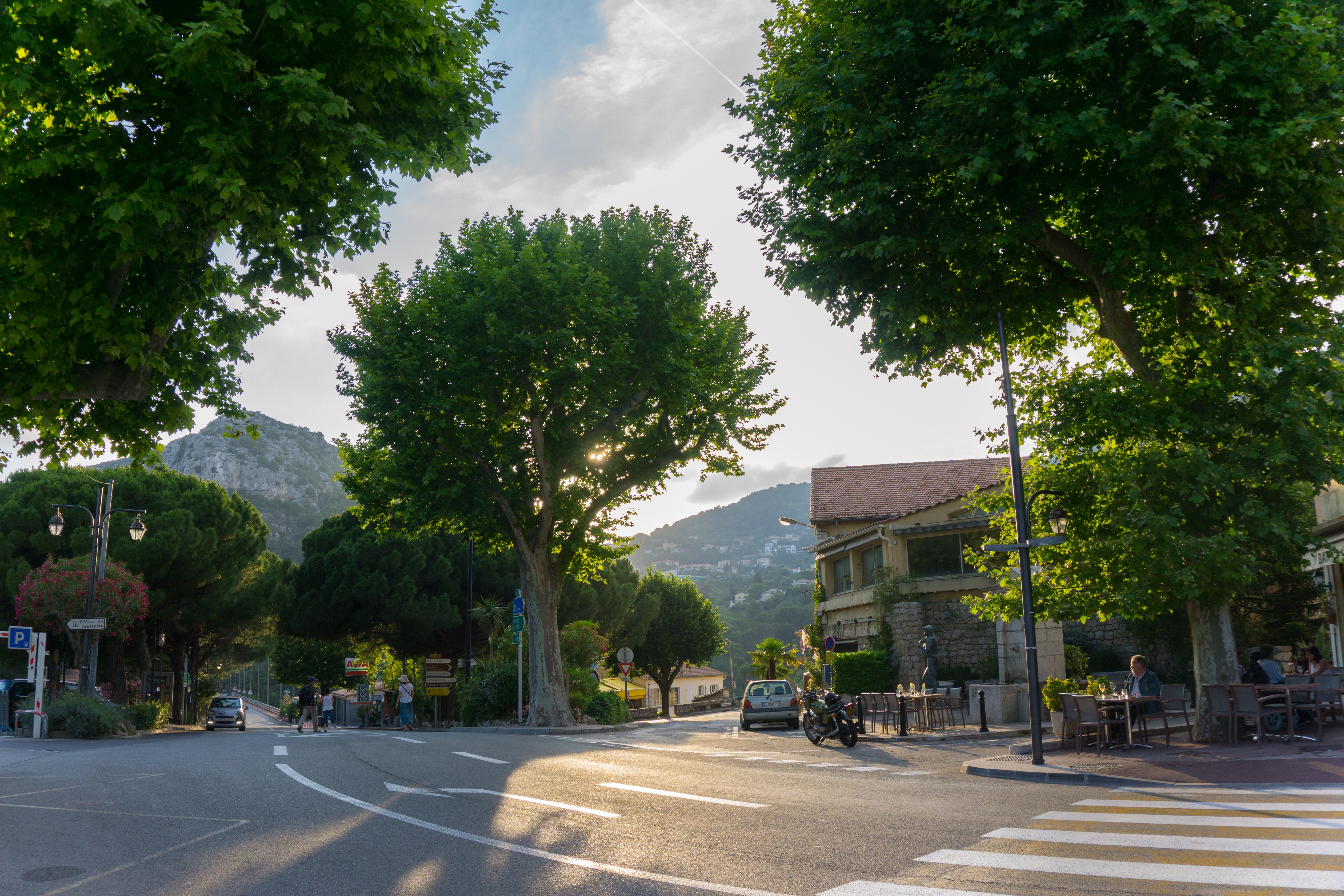 Street scene in Eze, France with trees and buildings HD Wallpaper