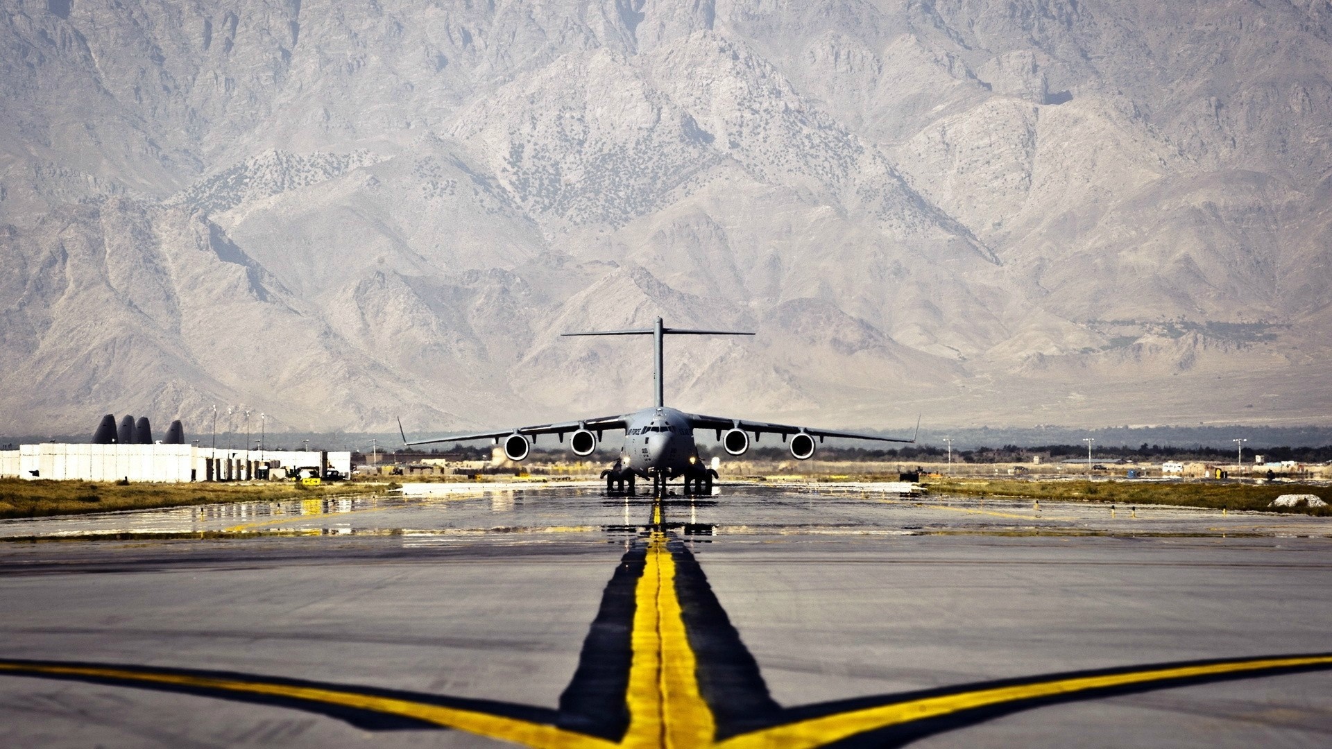 Boeing C-17 Globemaster III on a runway with mountains HD Wallpaper