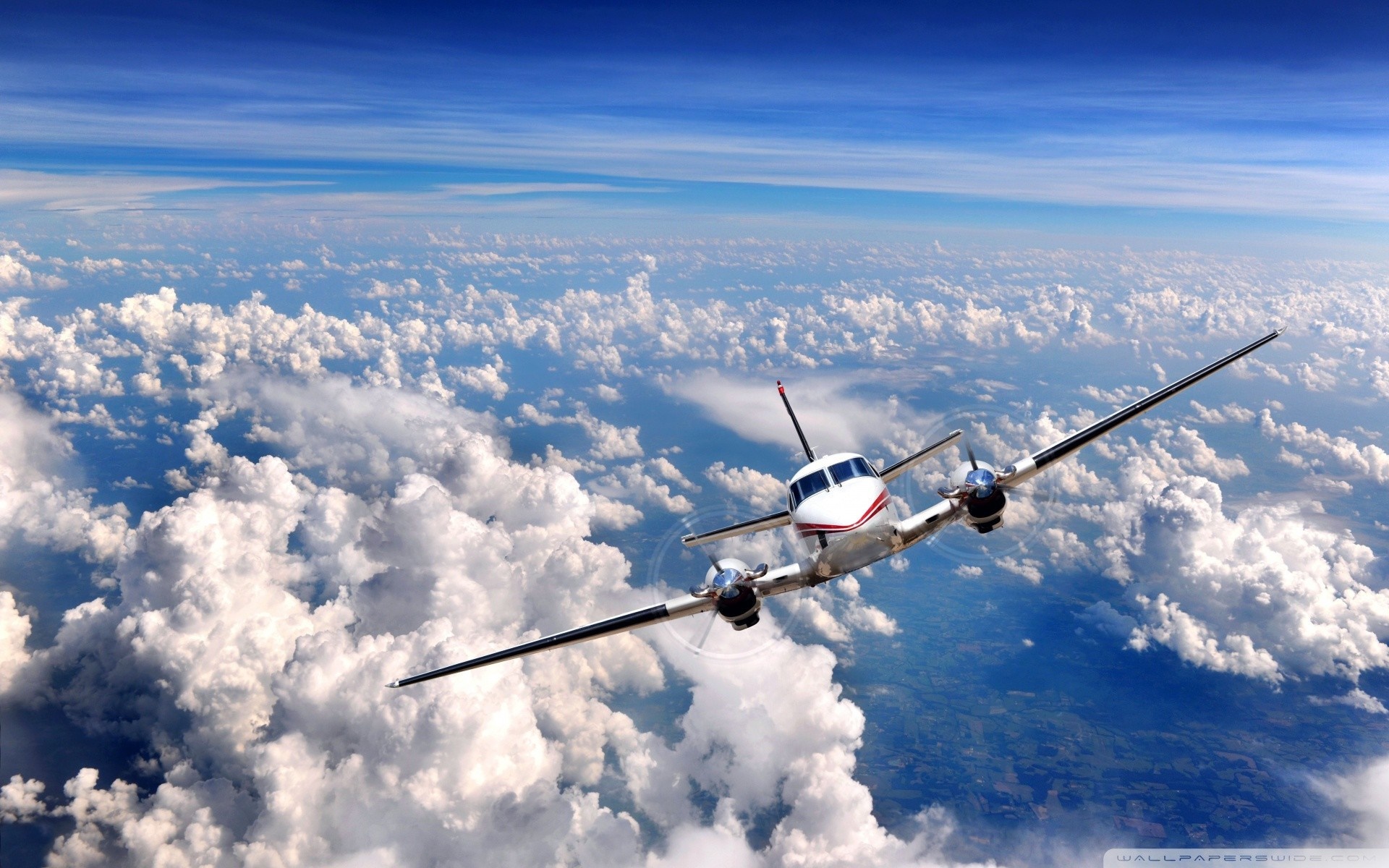 Twin-engine airplane flying above clouds HD Wallpaper