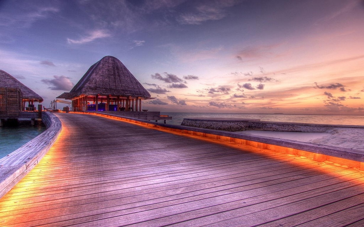 Wooden walkway to huts at sunset in the Maldives HD Wallpaper