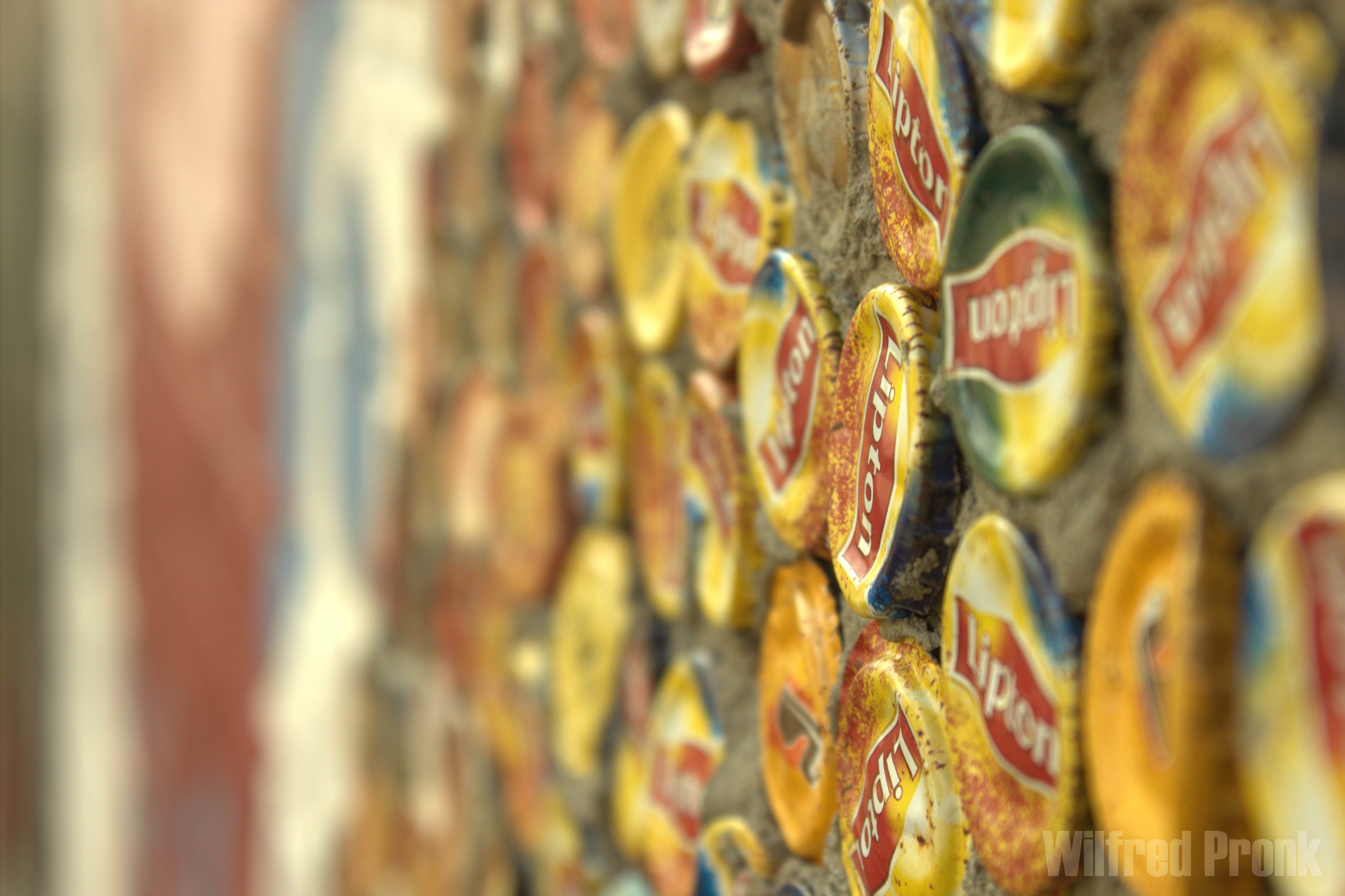 Close up of Lipton bottle caps on a wall HD Wallpaper
