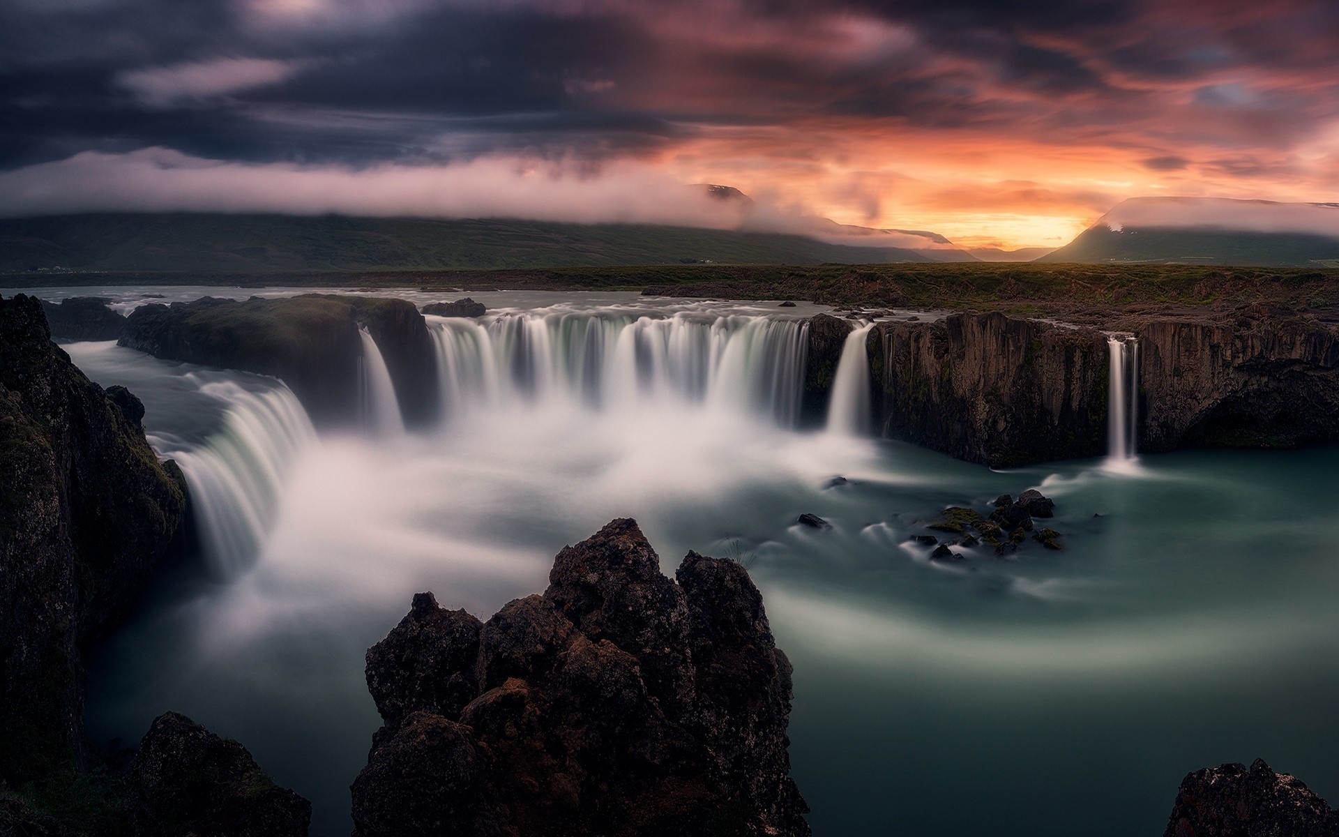 Waterfall at sunset with dramatic clouds HD Wallpaper