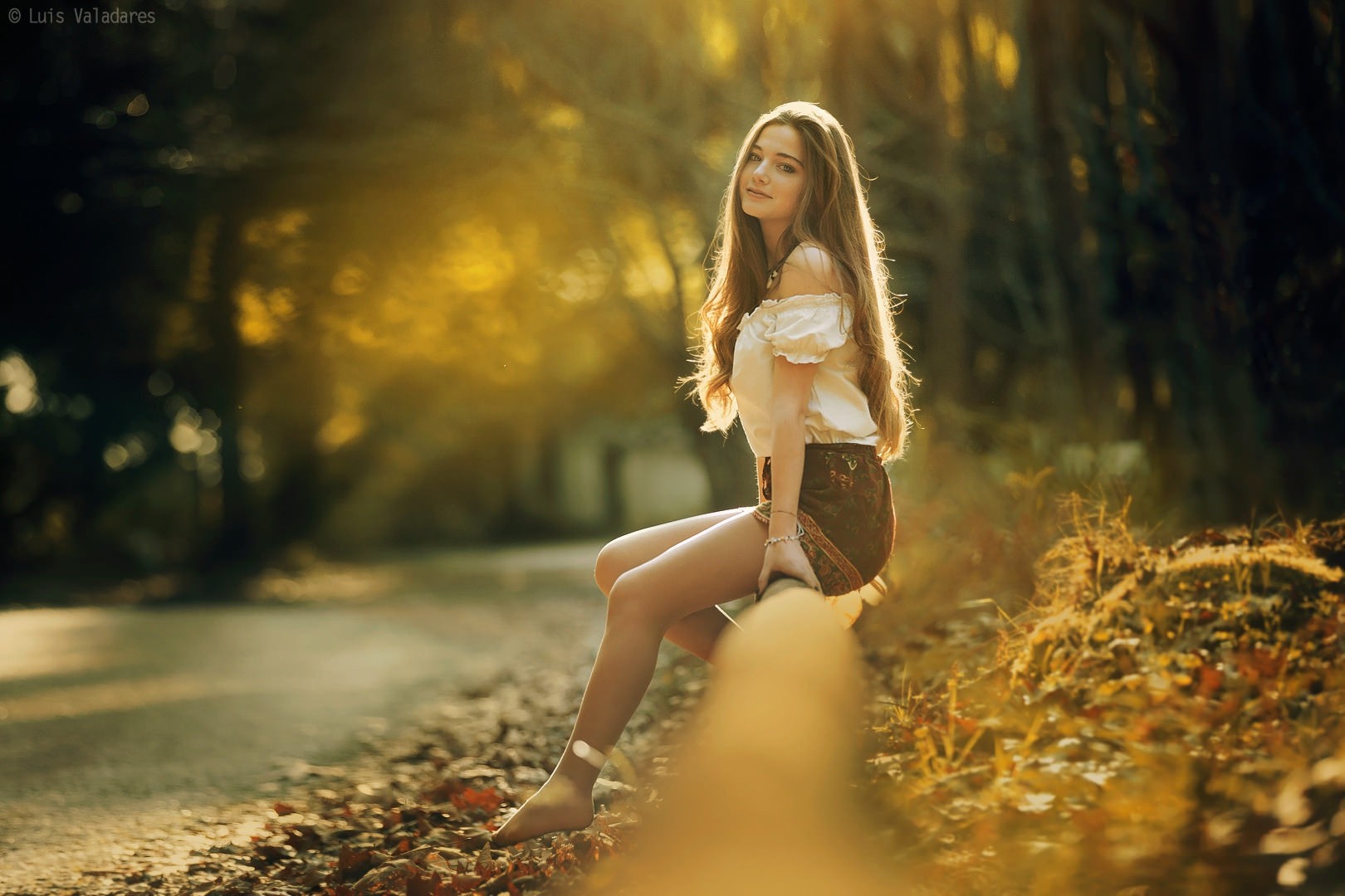 Young woman sitting on a log in an autumn forest HD Wallpaper
