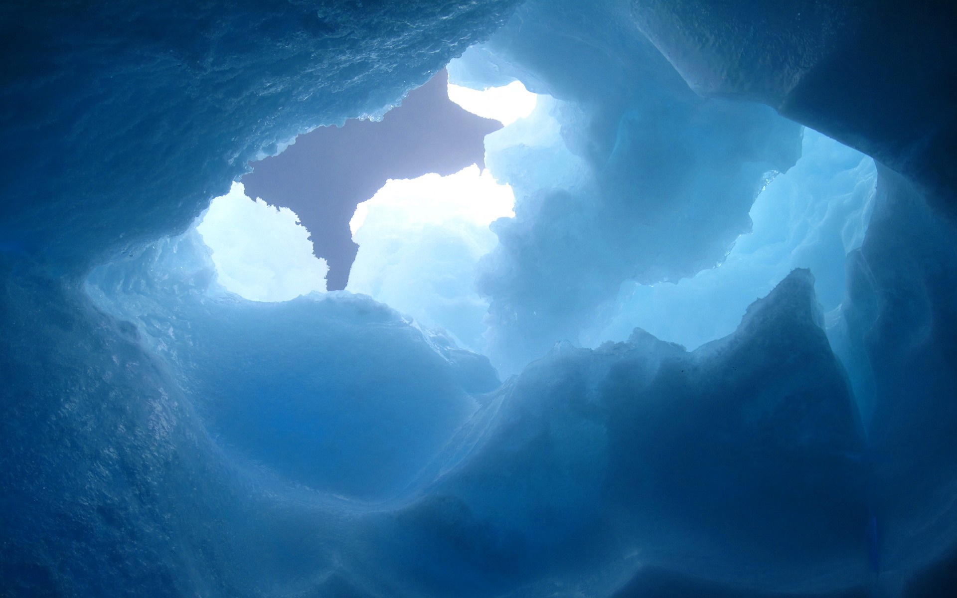 Looking up through an ice cave opening to the sky HD Wallpaper