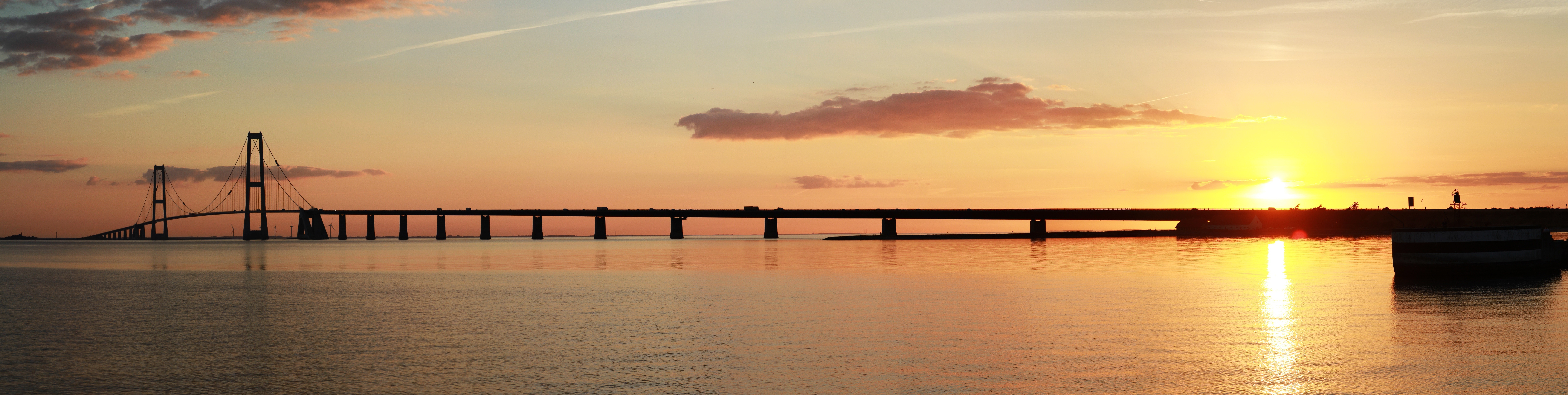 Bridge over sea at sunset with reflections HD Wallpaper