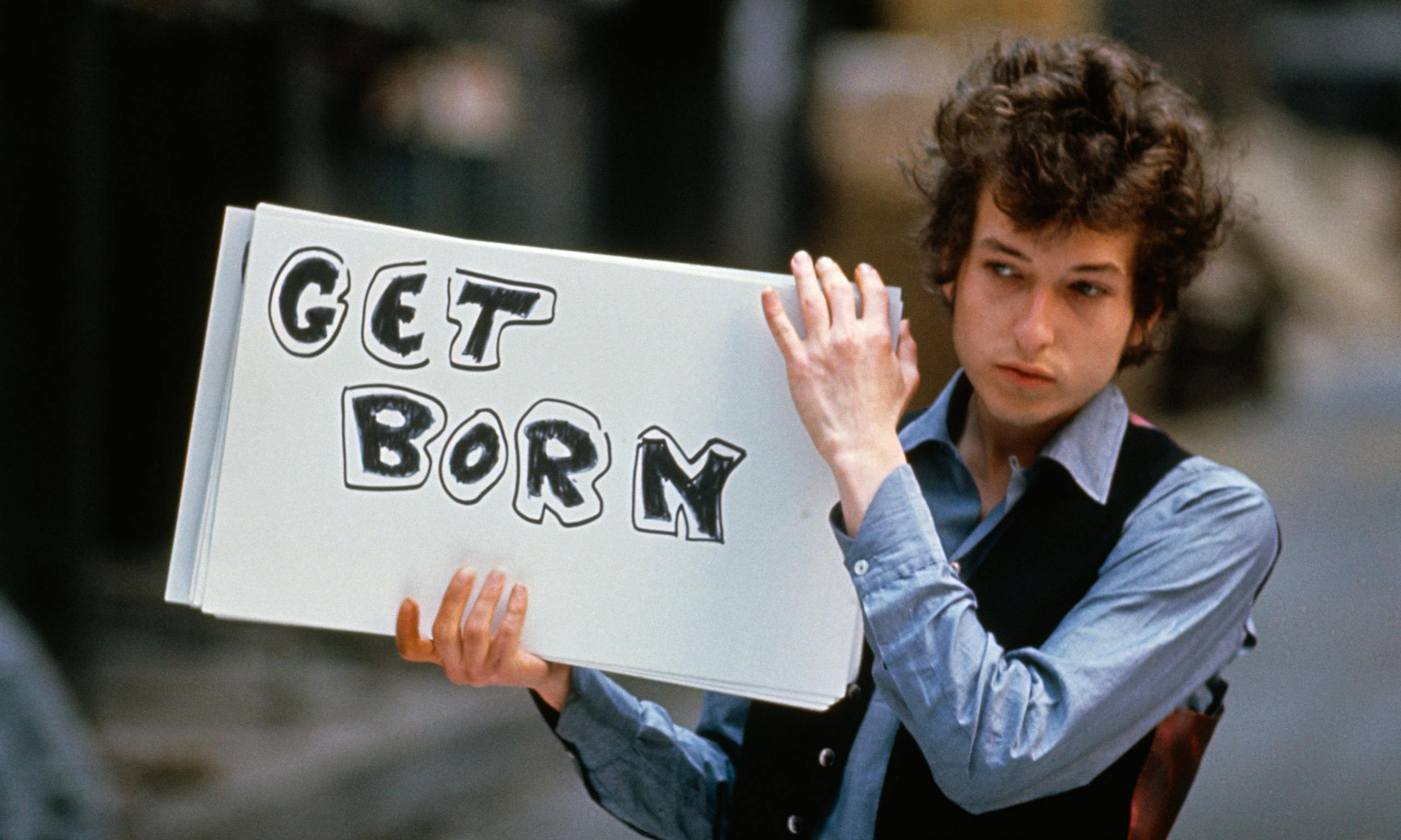 Bob Dylan holding a sign that says GET BORN HD Wallpaper