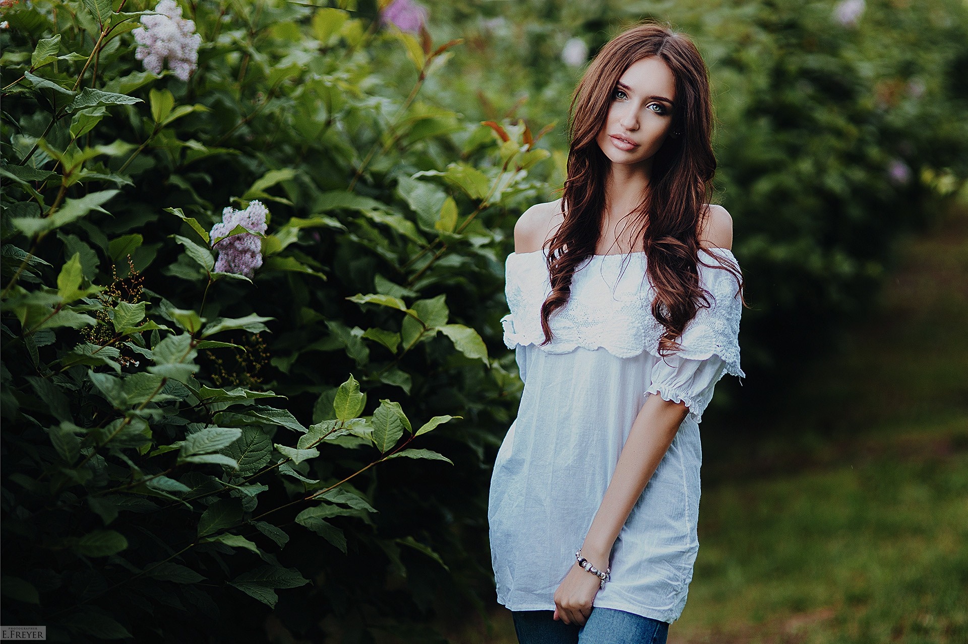 Woman in white off-the-shoulder top and jeans outdoors HD Wallpaper