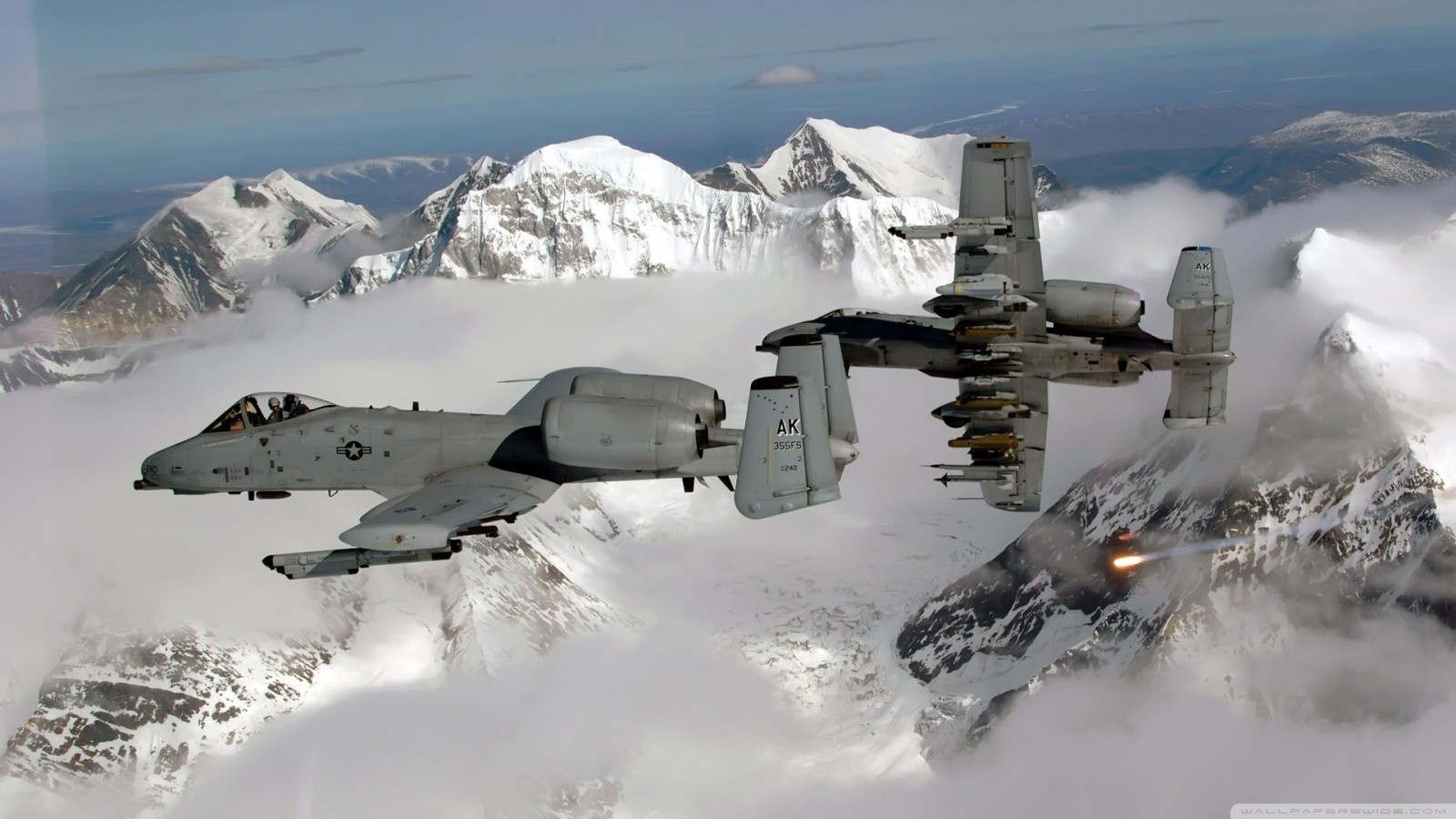 Two A-10 Thunderbolt II aircraft flying over snowy mountains HD Wallpaper