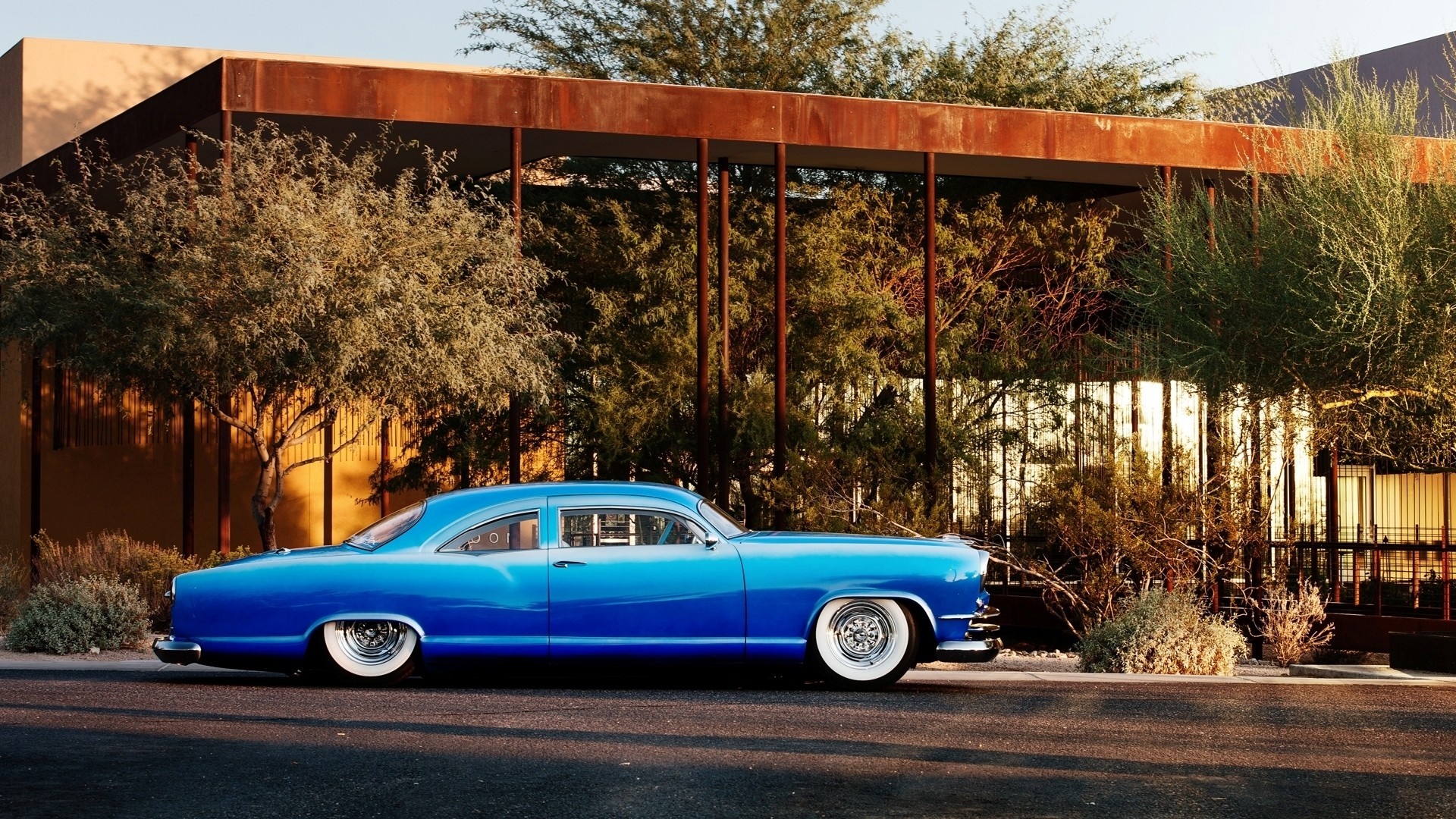 Blue vintage Chevrolet Kaiser car parked in front of a modern building HD Wallpaper
