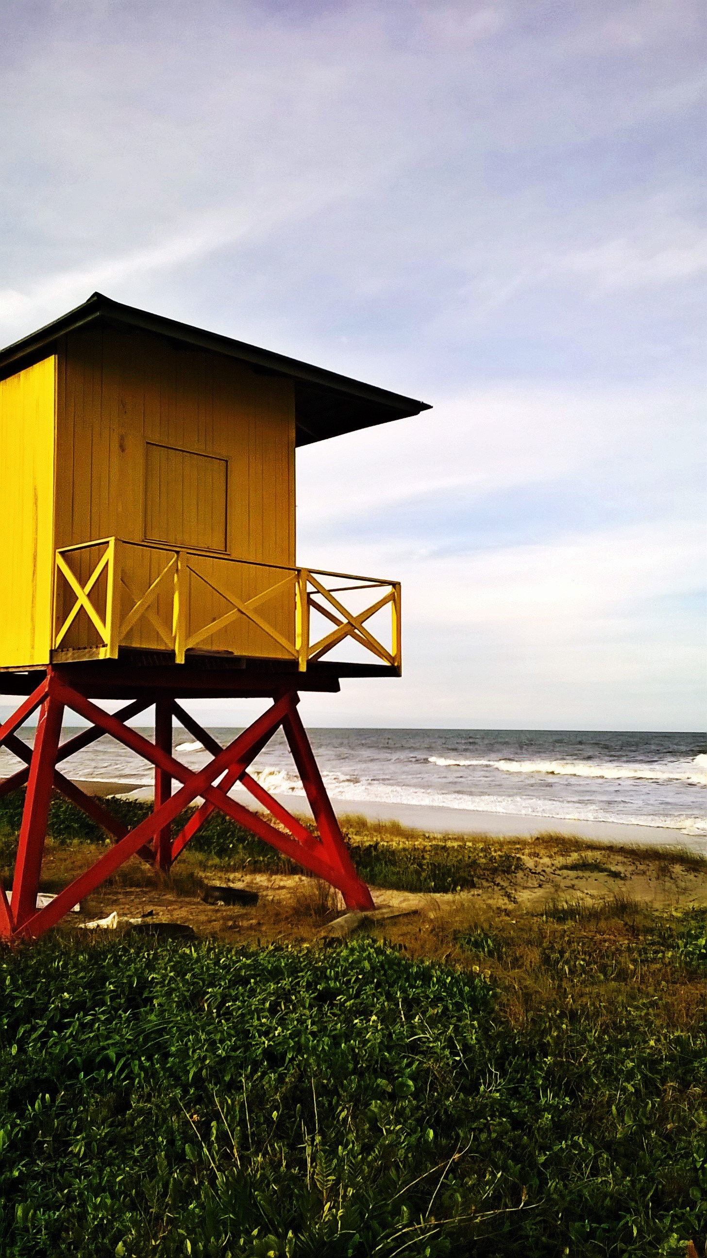 Yellow lifeguard tower on a beach with ocean waves HD Wallpaper