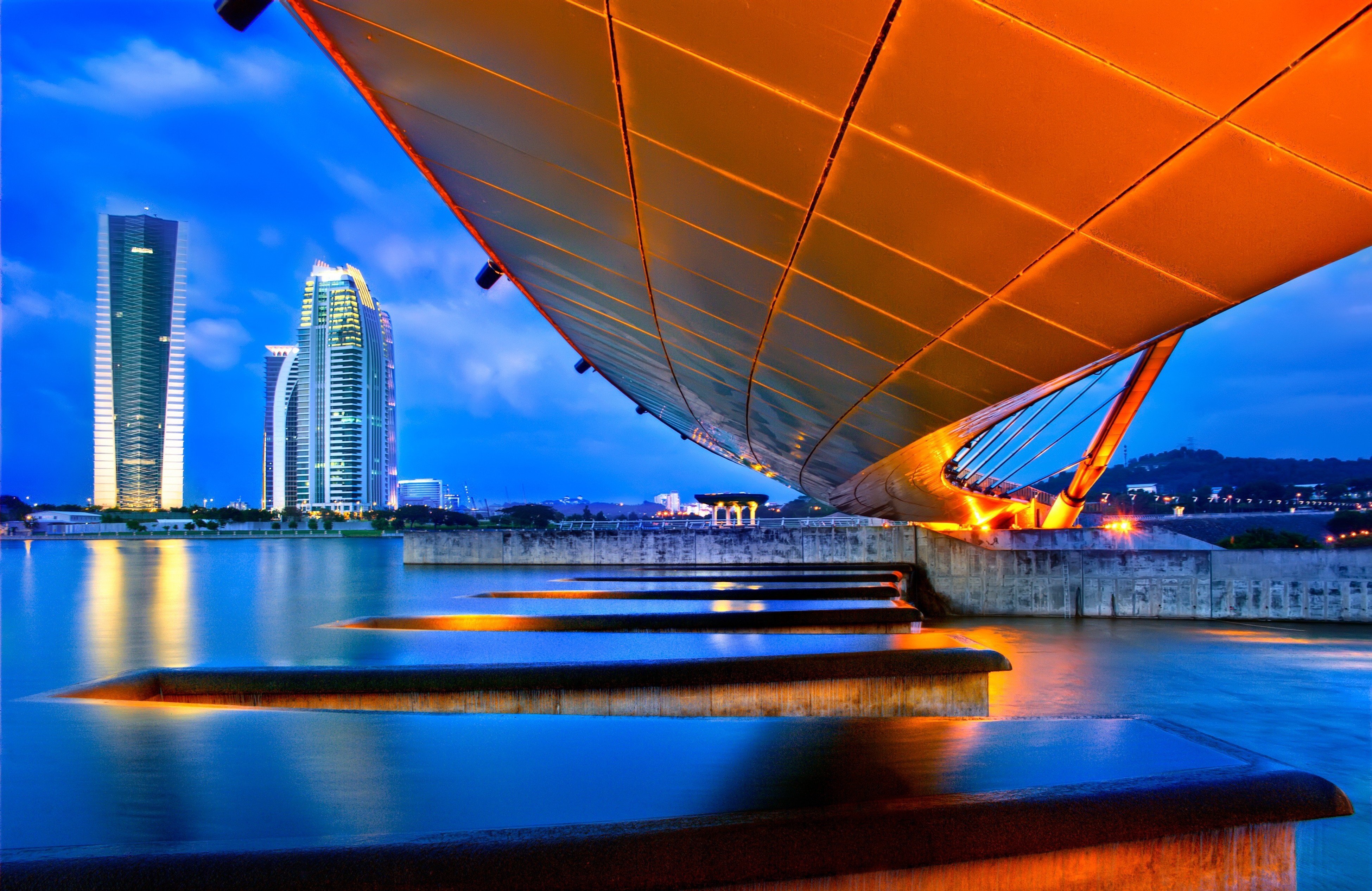 Modern bridge over water with city skyline at dusk HD Wallpaper
