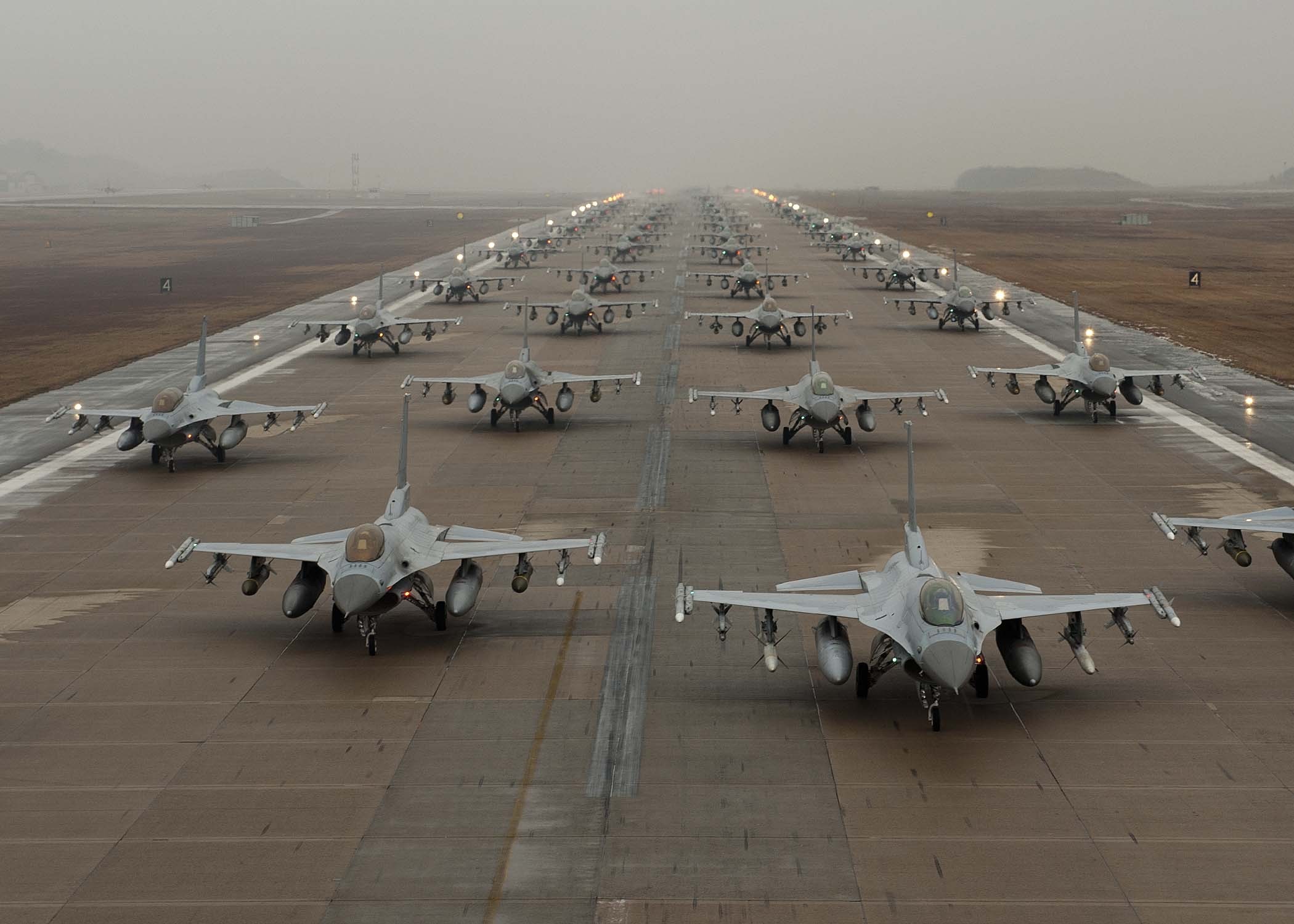 F-16 Fighting Falcons lined up on a runway HD Wallpaper