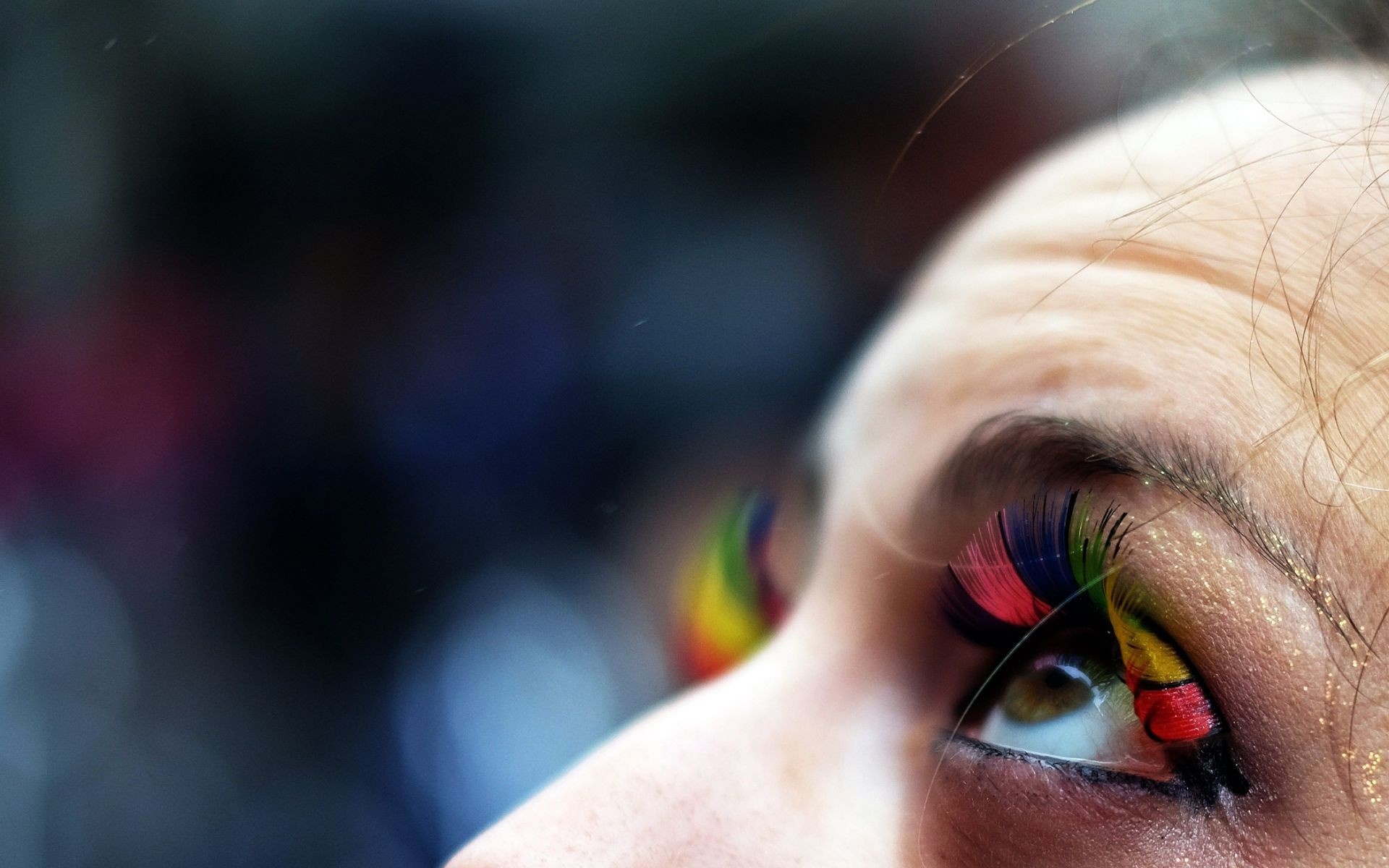 Close-up of a person's eye with rainbow-colored eyelashes HD Wallpaper