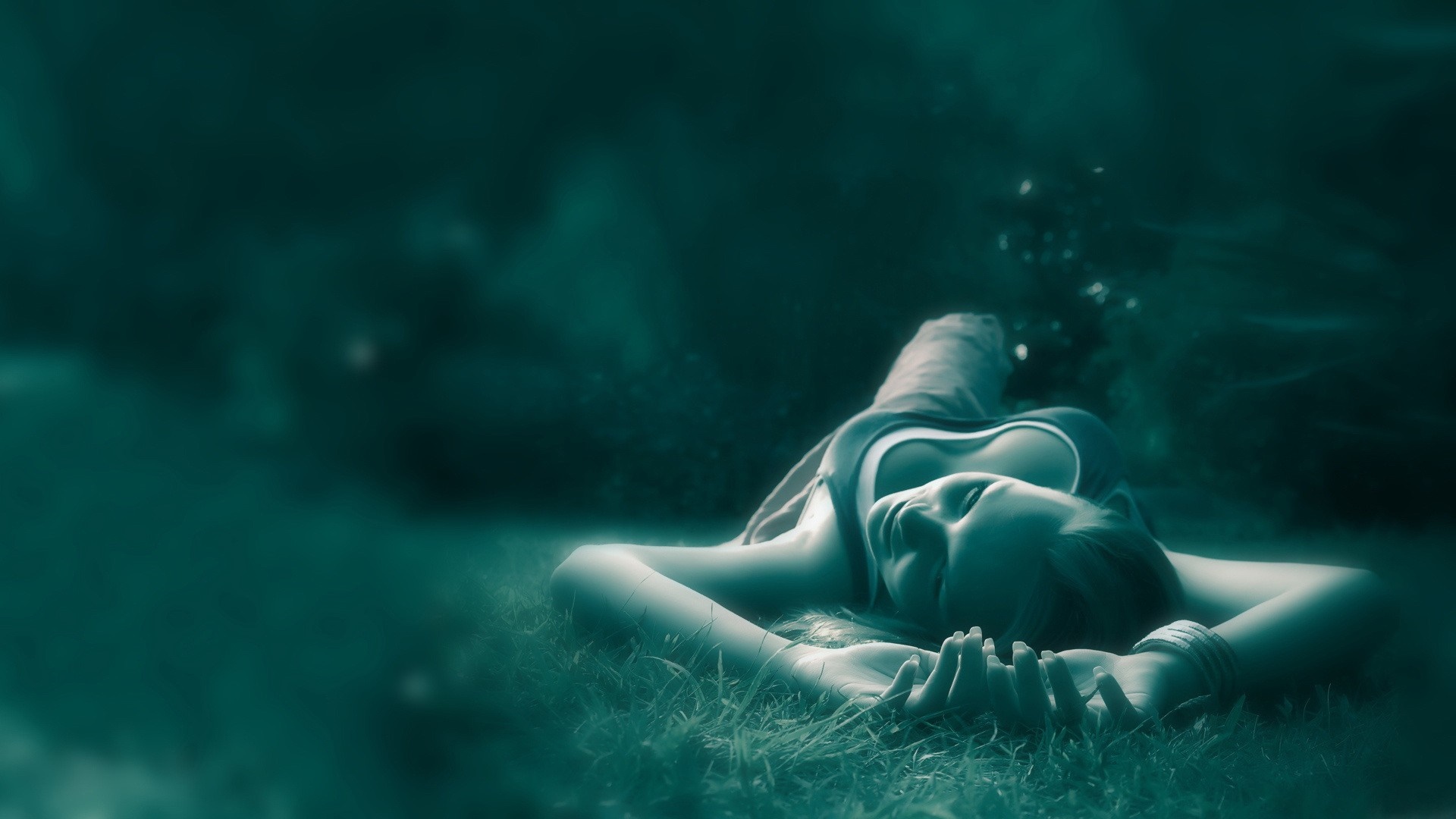 Woman lying on grass with dark background HD Wallpaper