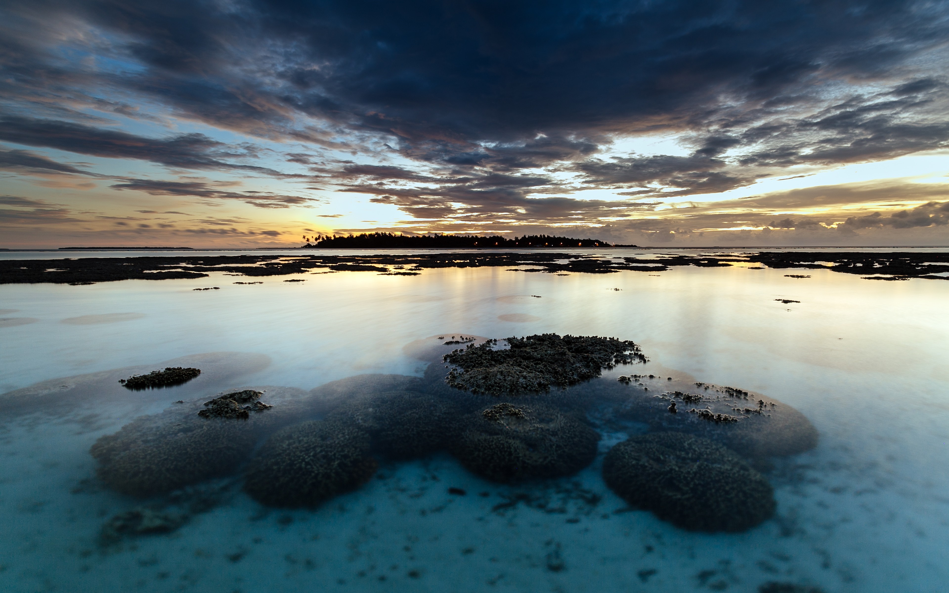 Sunset over a tropical island lagoon with coral formations HD Wallpaper