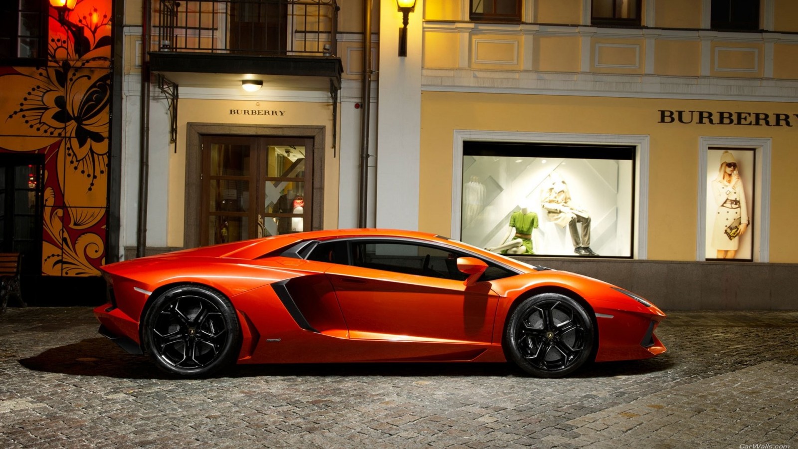 Orange Lamborghini Aventador parked in front of Burberry store HD Wallpaper