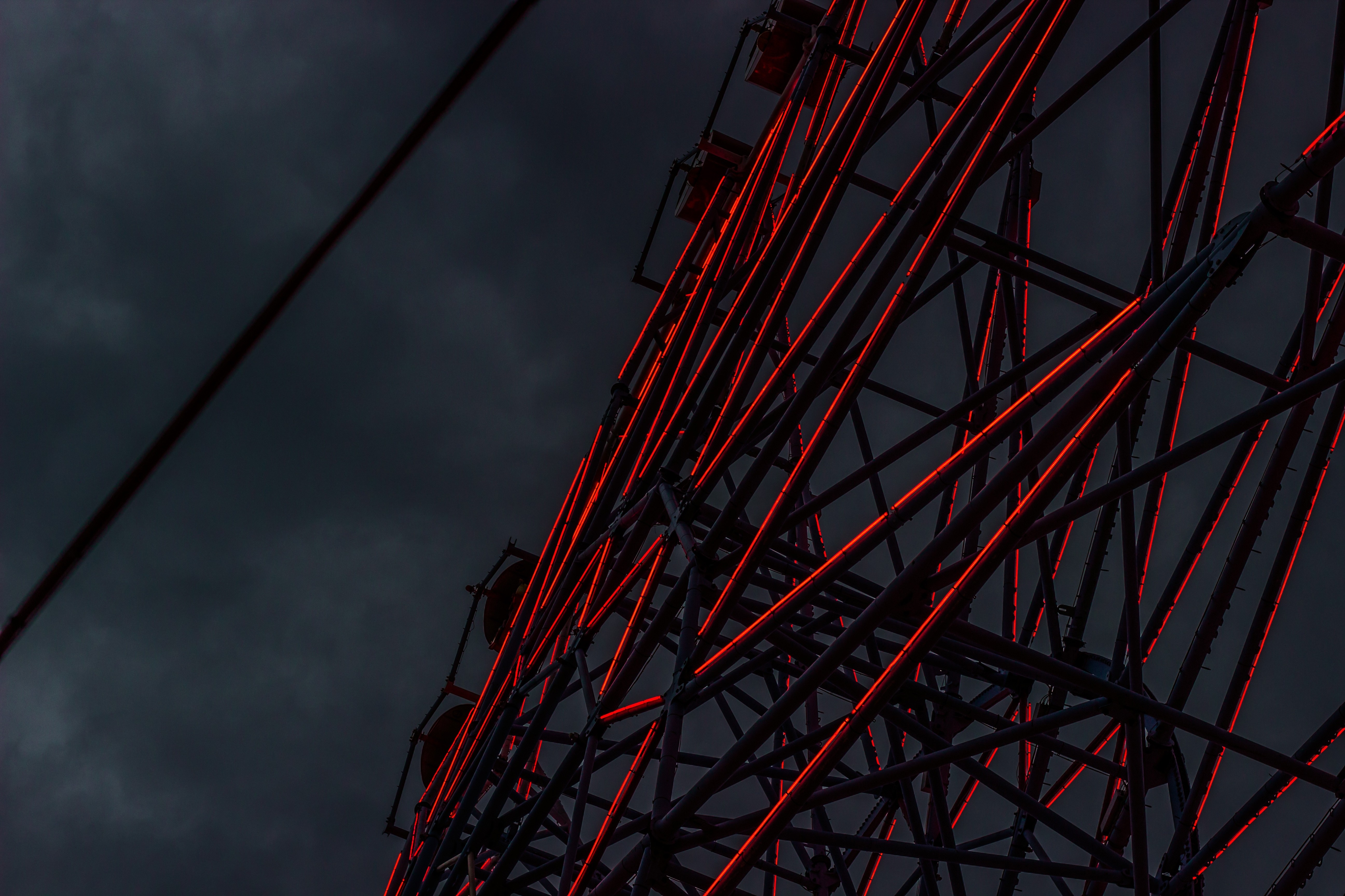 Ferris wheel with red lights against dark sky HD Wallpaper