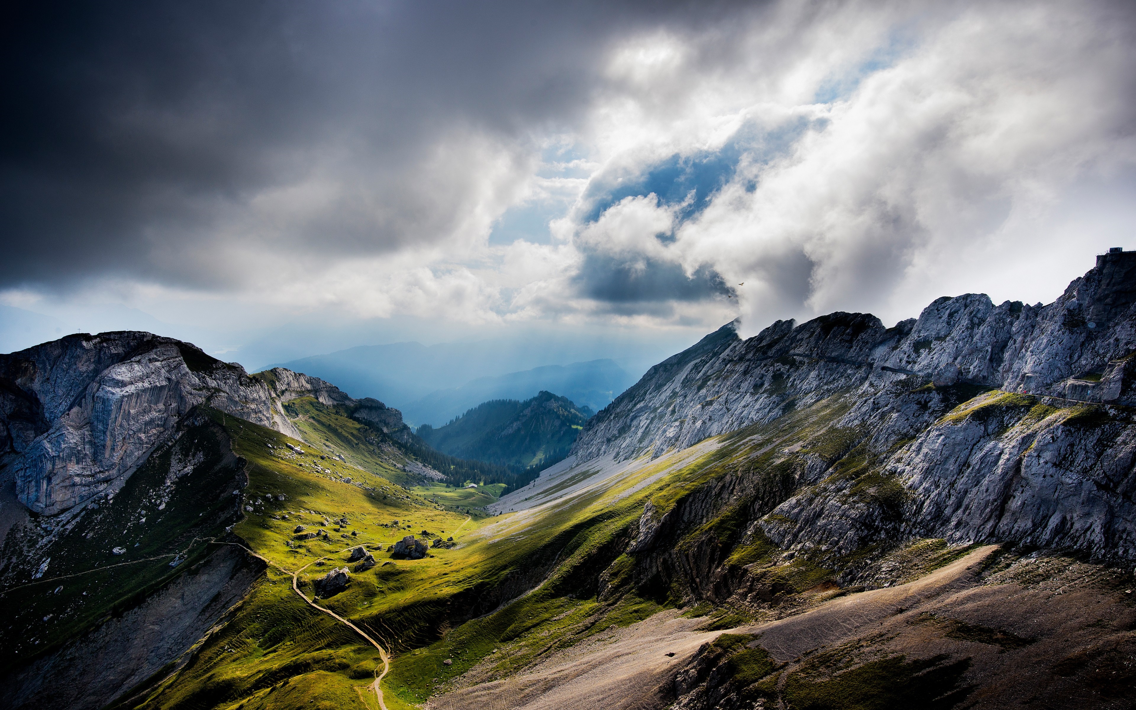 Dramatic mountain landscape with stormy clouds and sunlit valley HD Wallpaper