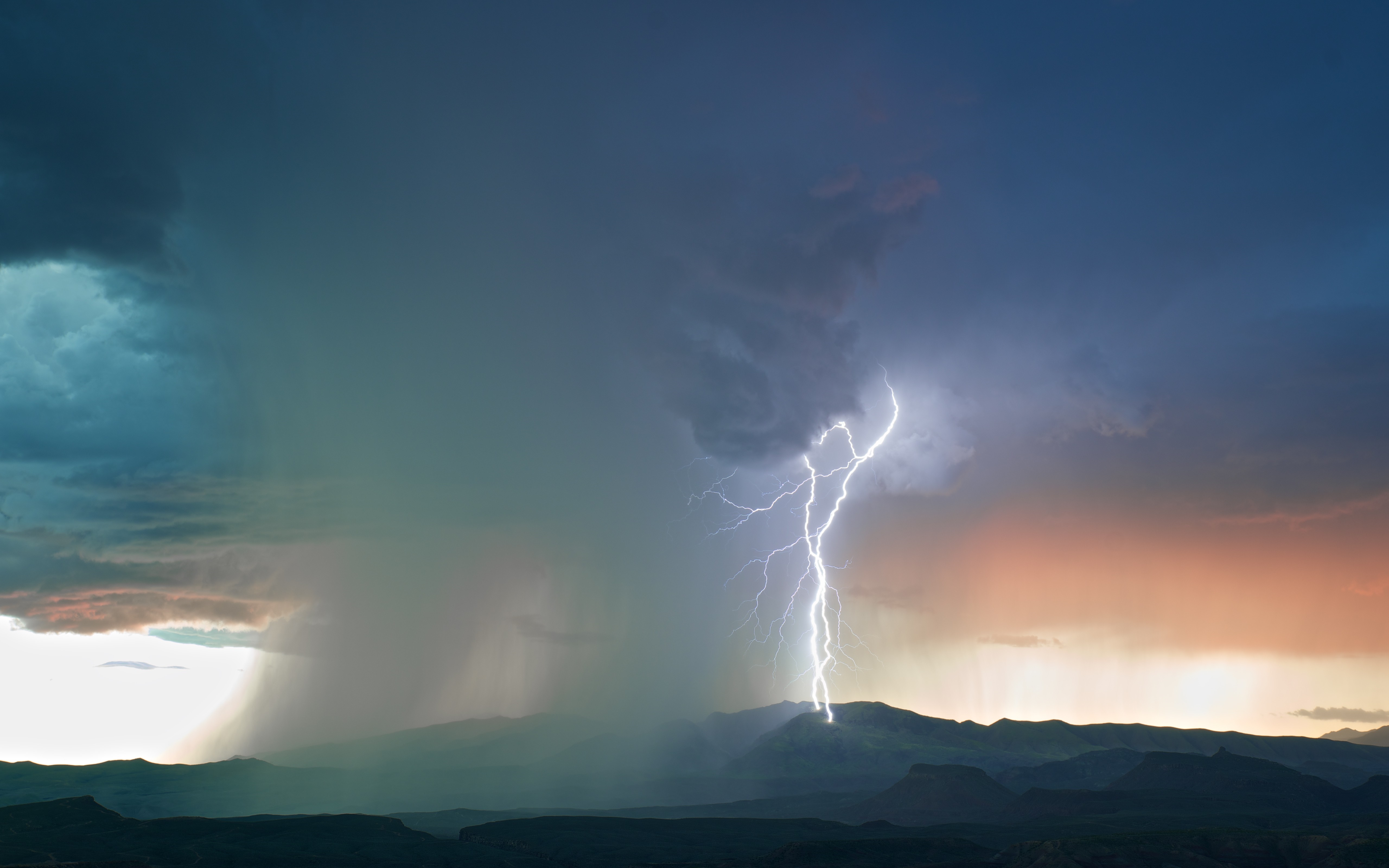 Lightning strike over mountains during a storm HD Wallpaper