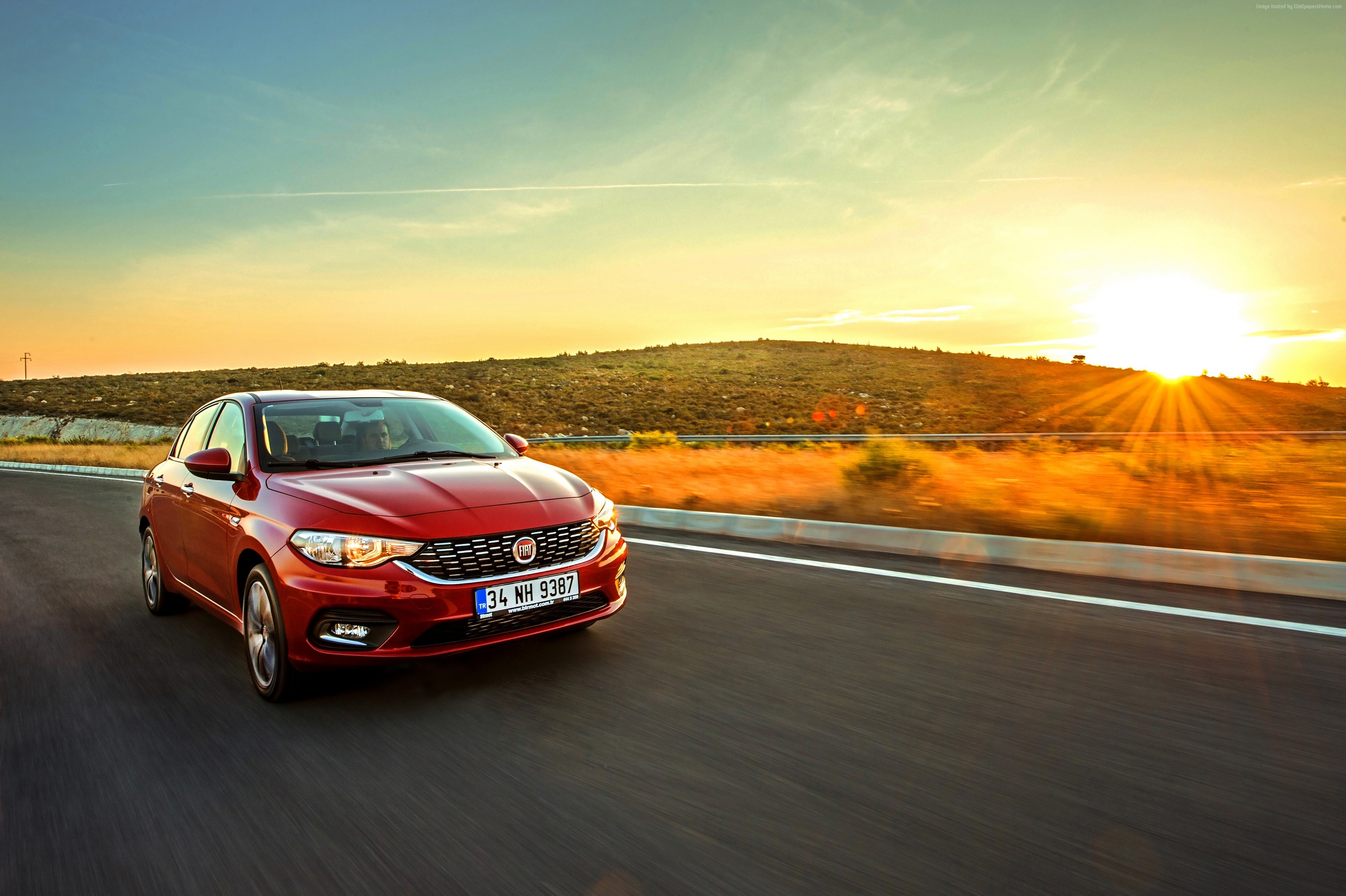 Red Fiat Egea driving on a road at sunset HD Wallpaper
