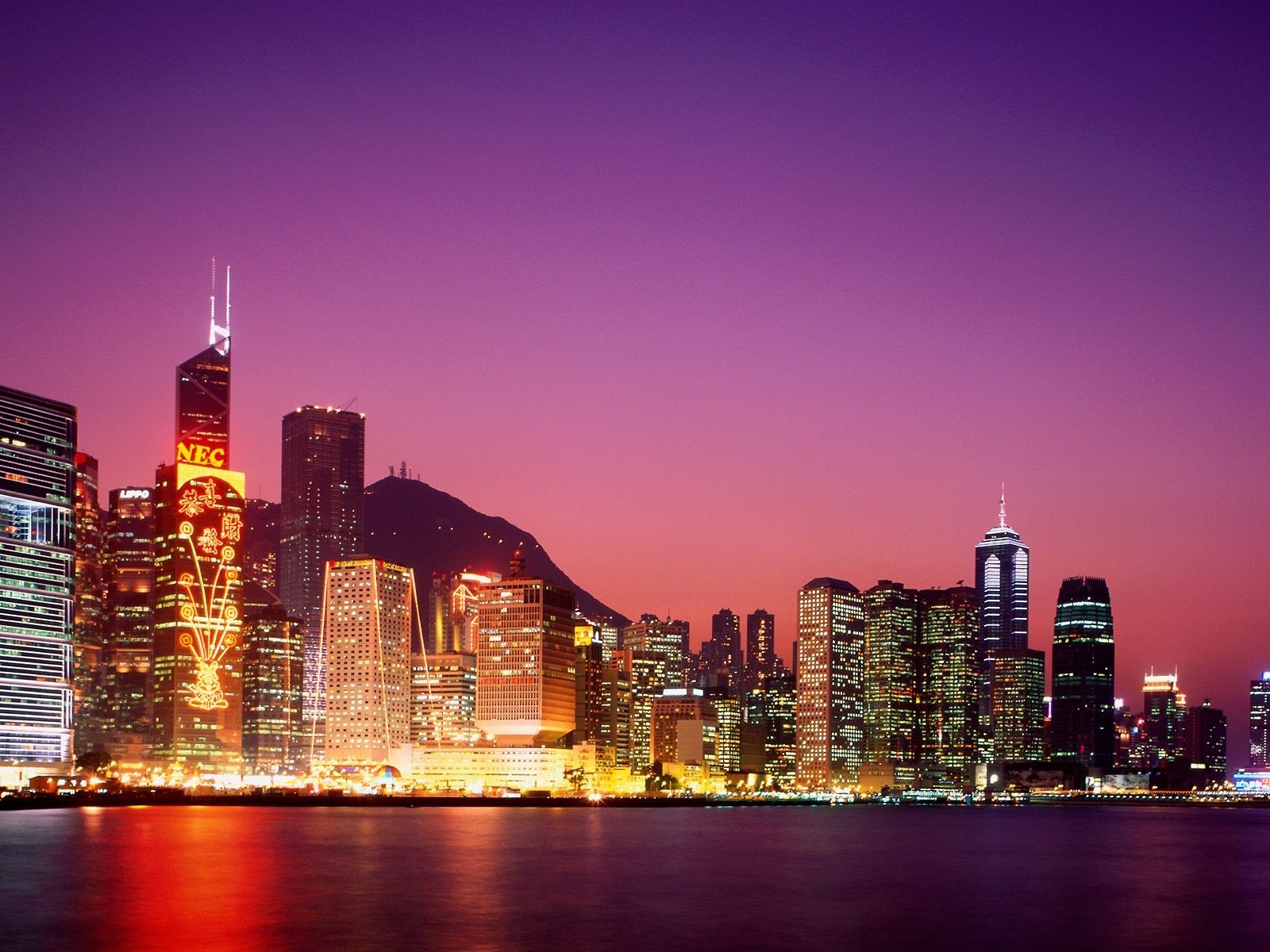 Hong Kong skyline at dusk with illuminated skyscrapers HD Wallpaper