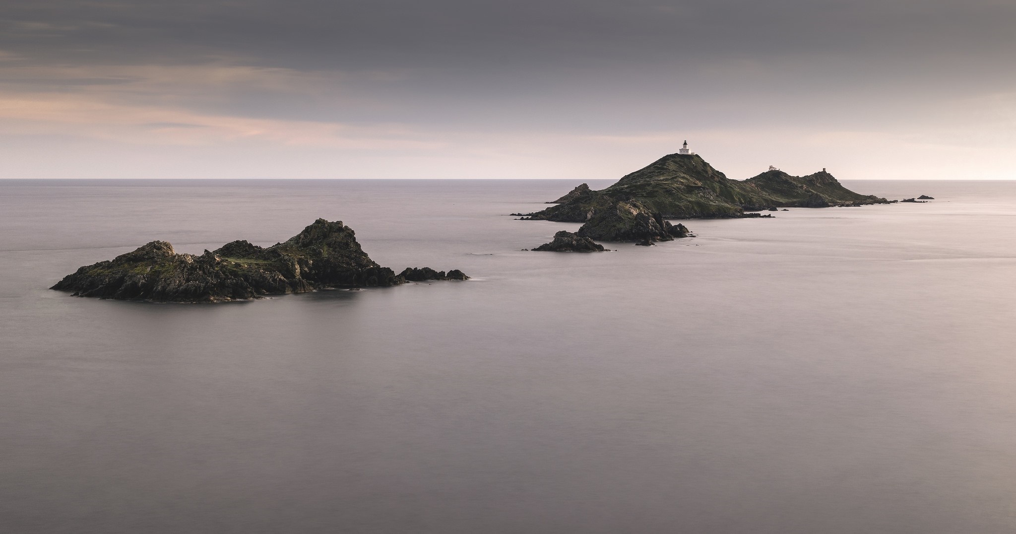 Islands with lighthouse in the sea at dusk HD Wallpaper