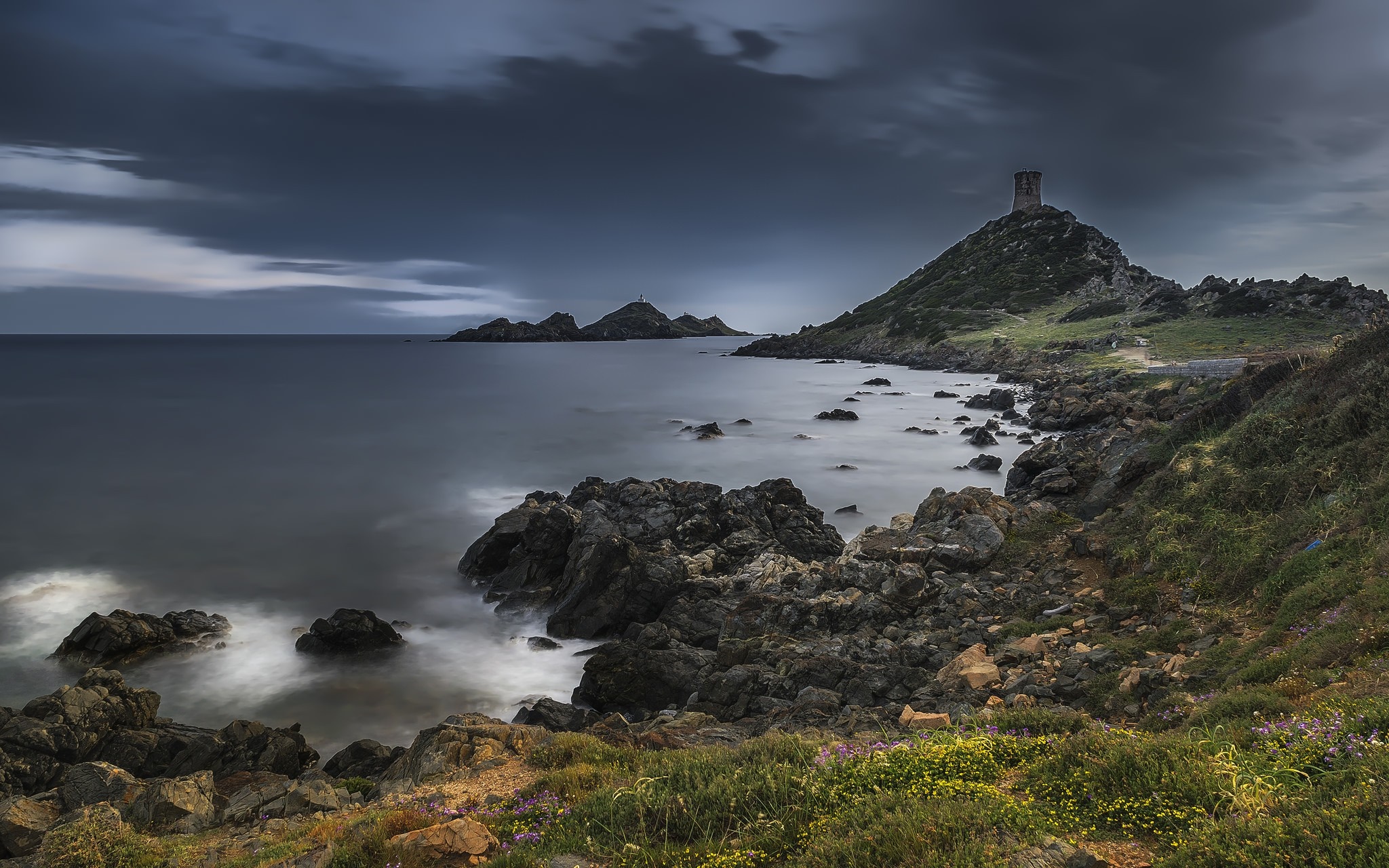 Rocky coast with a tower on a hill overlooking the sea HD Wallpaper