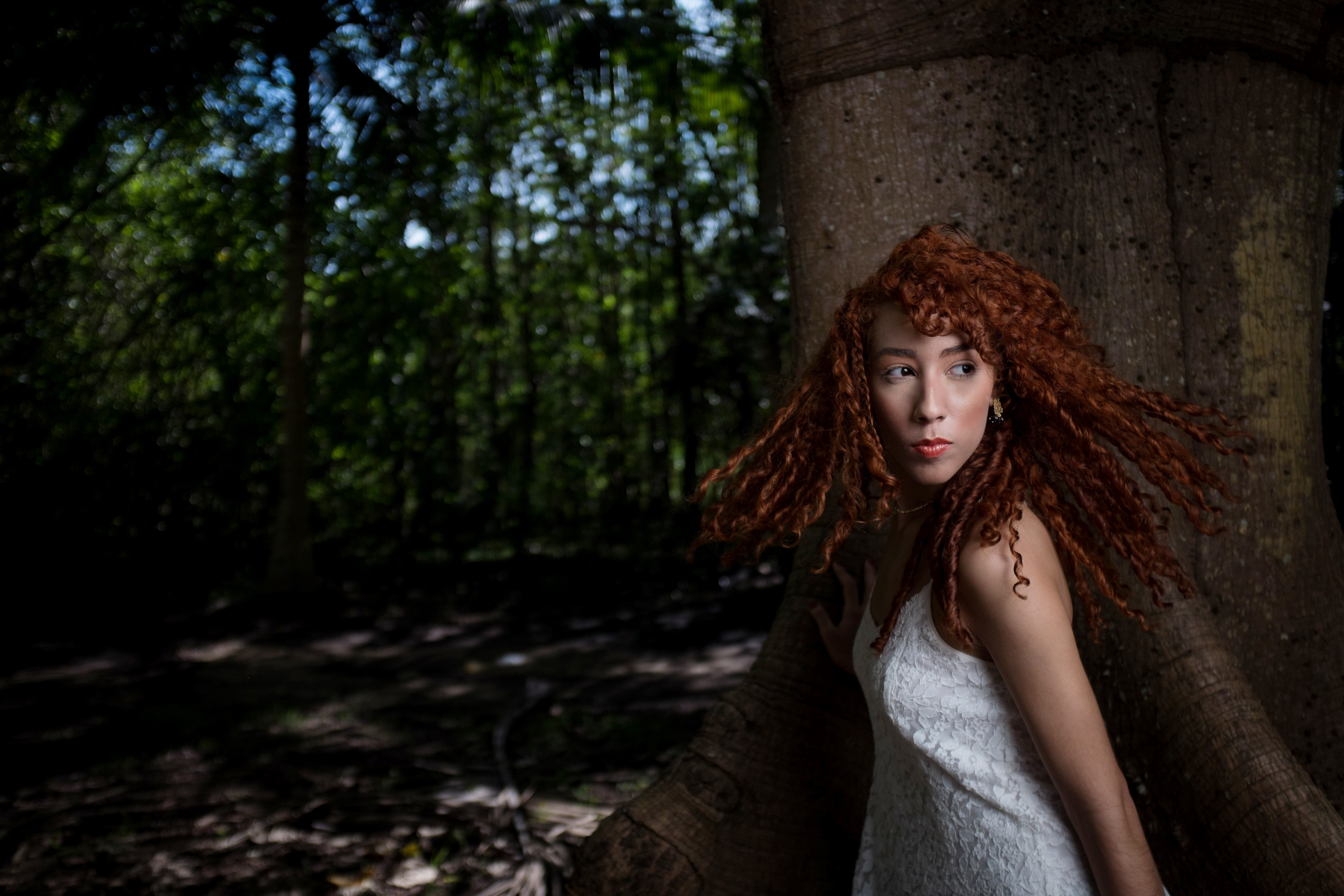 Woman with curly red hair in a white dress in a forest HD Wallpaper