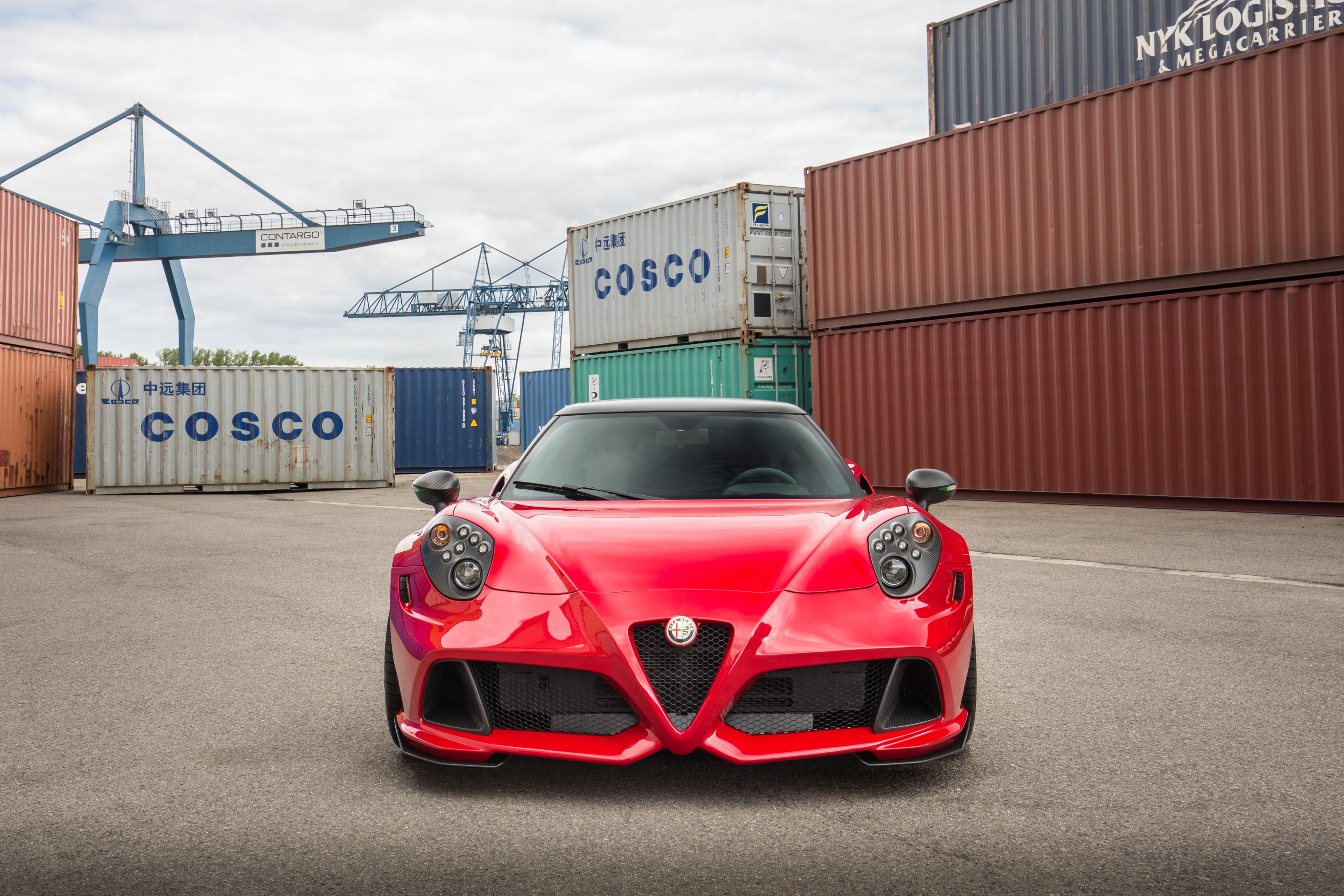 Red Alfa Romeo sports car at a shipping port HD Wallpaper