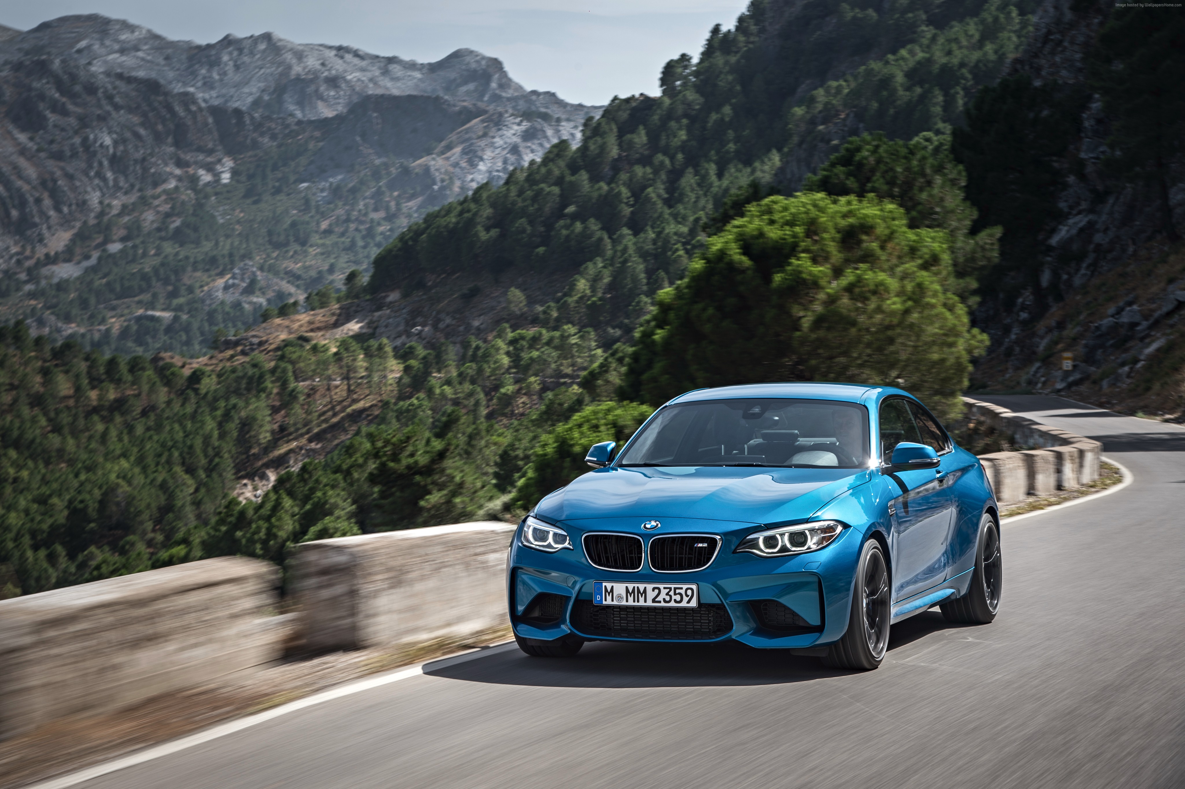 Blue BMW M2 driving on a mountain road HD Wallpaper
