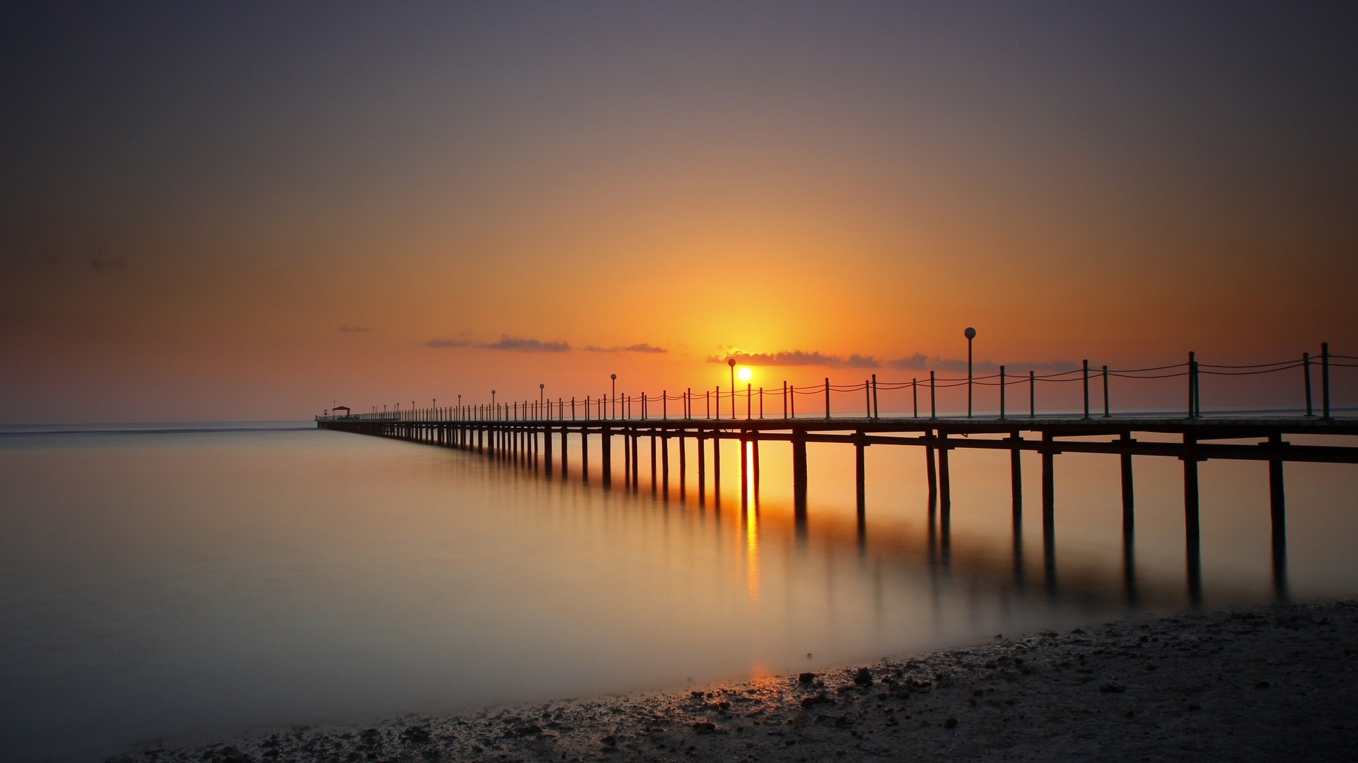 Pier at sunset over calm water HD Wallpaper